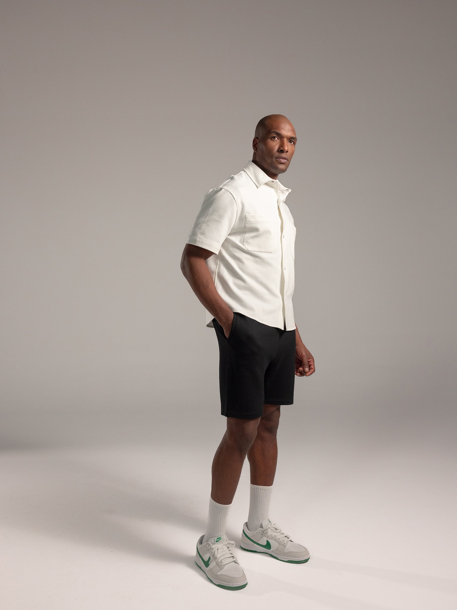 Man wearing white button down and black cityscape shorts
