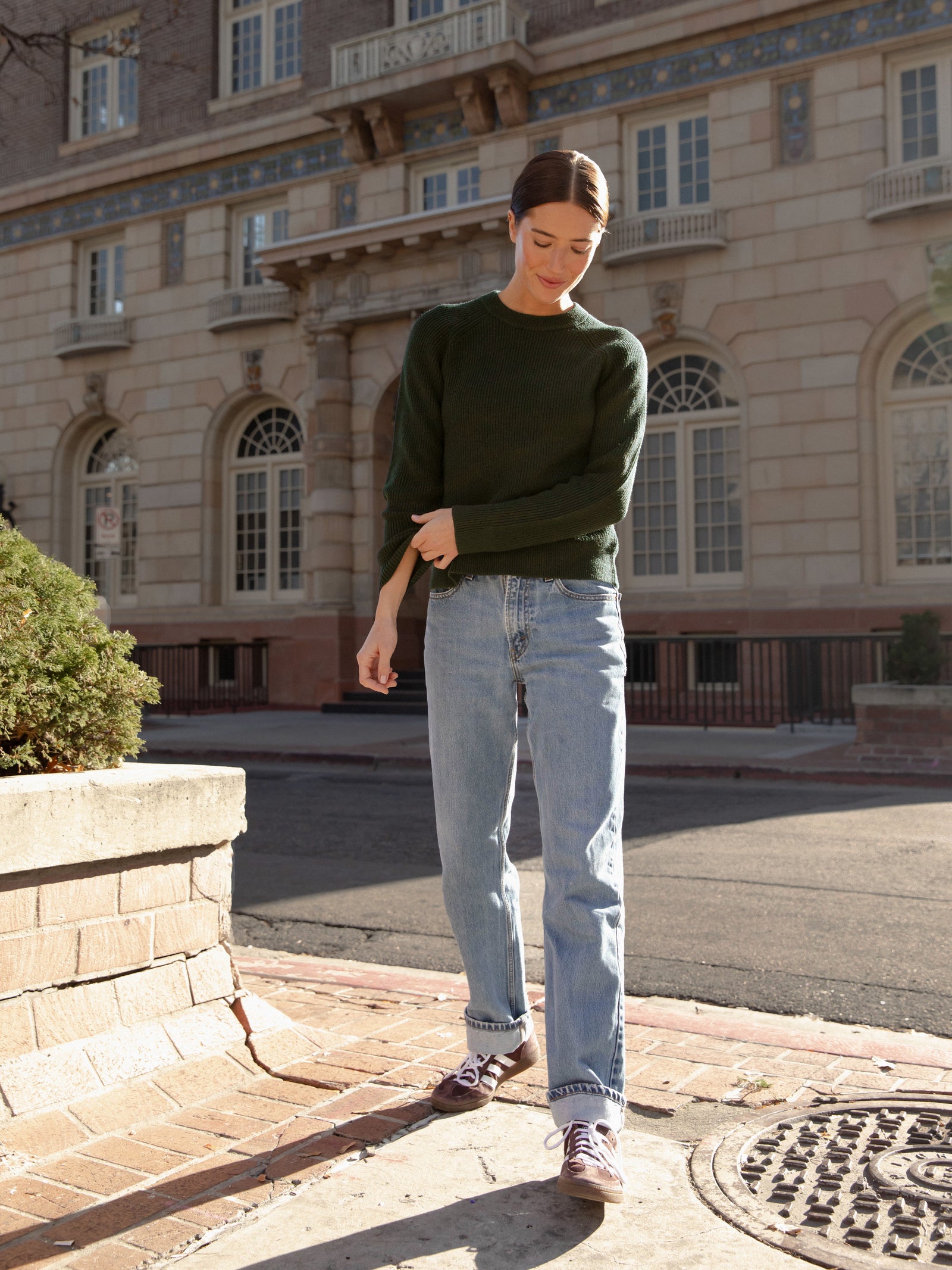 Woman wearing juniper classic crewneck and jeans on city street