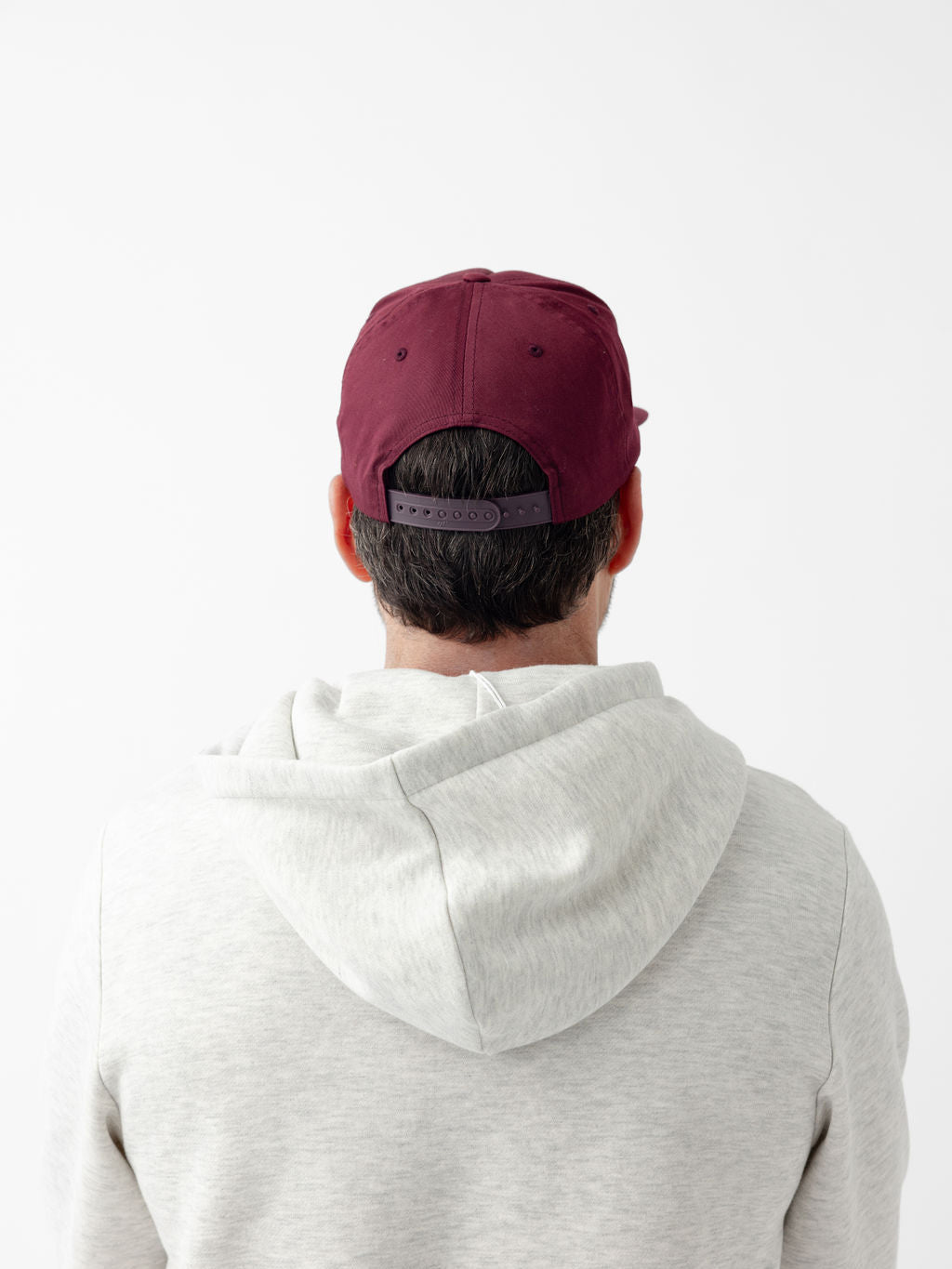 back of man wearing maroon heritage snapback 