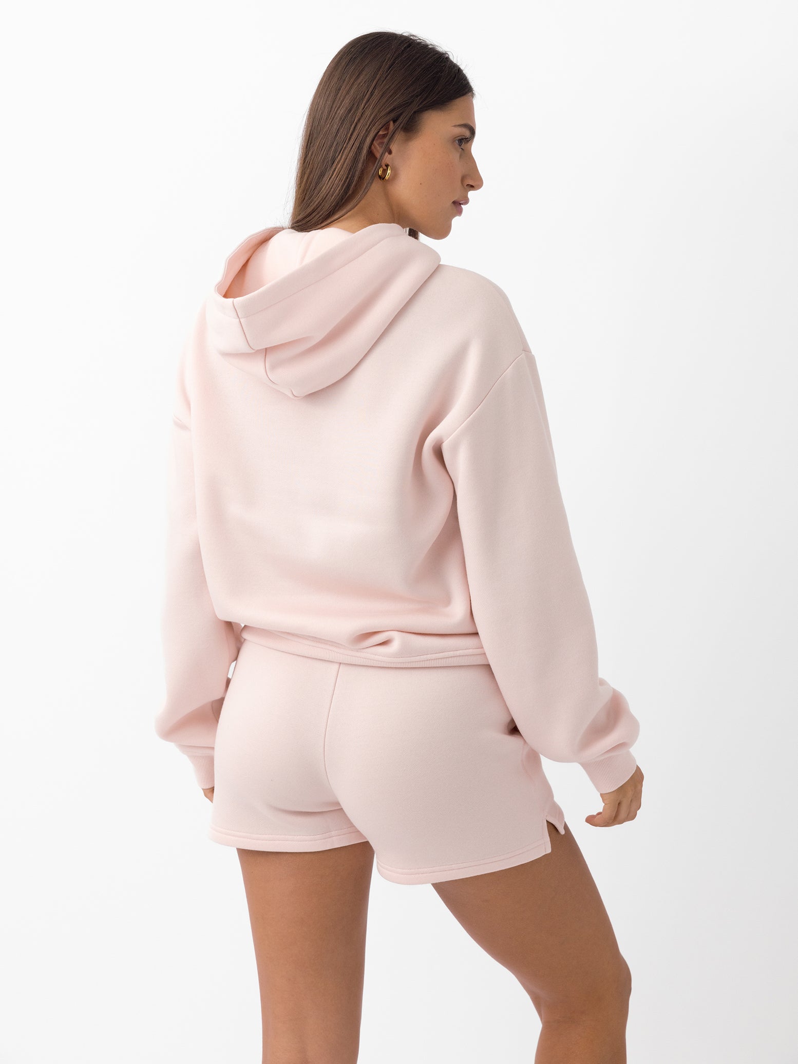 Back of woman wearing peony cityscape hoodie and shorts with white background 