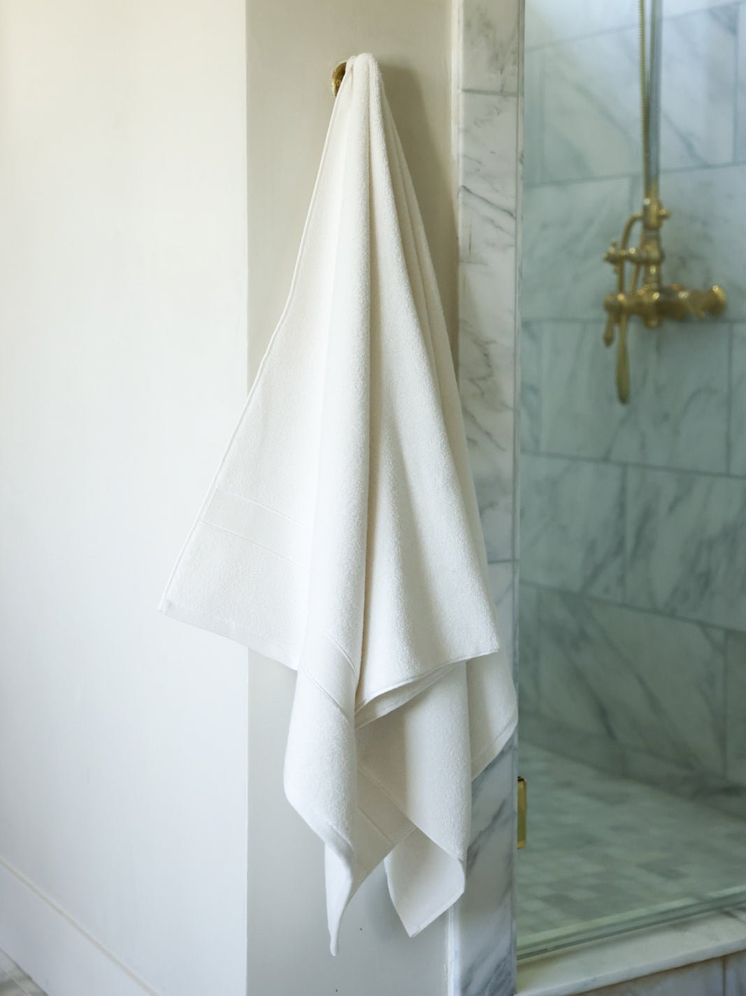 Seashell luxe bath sheet hanging next to shower