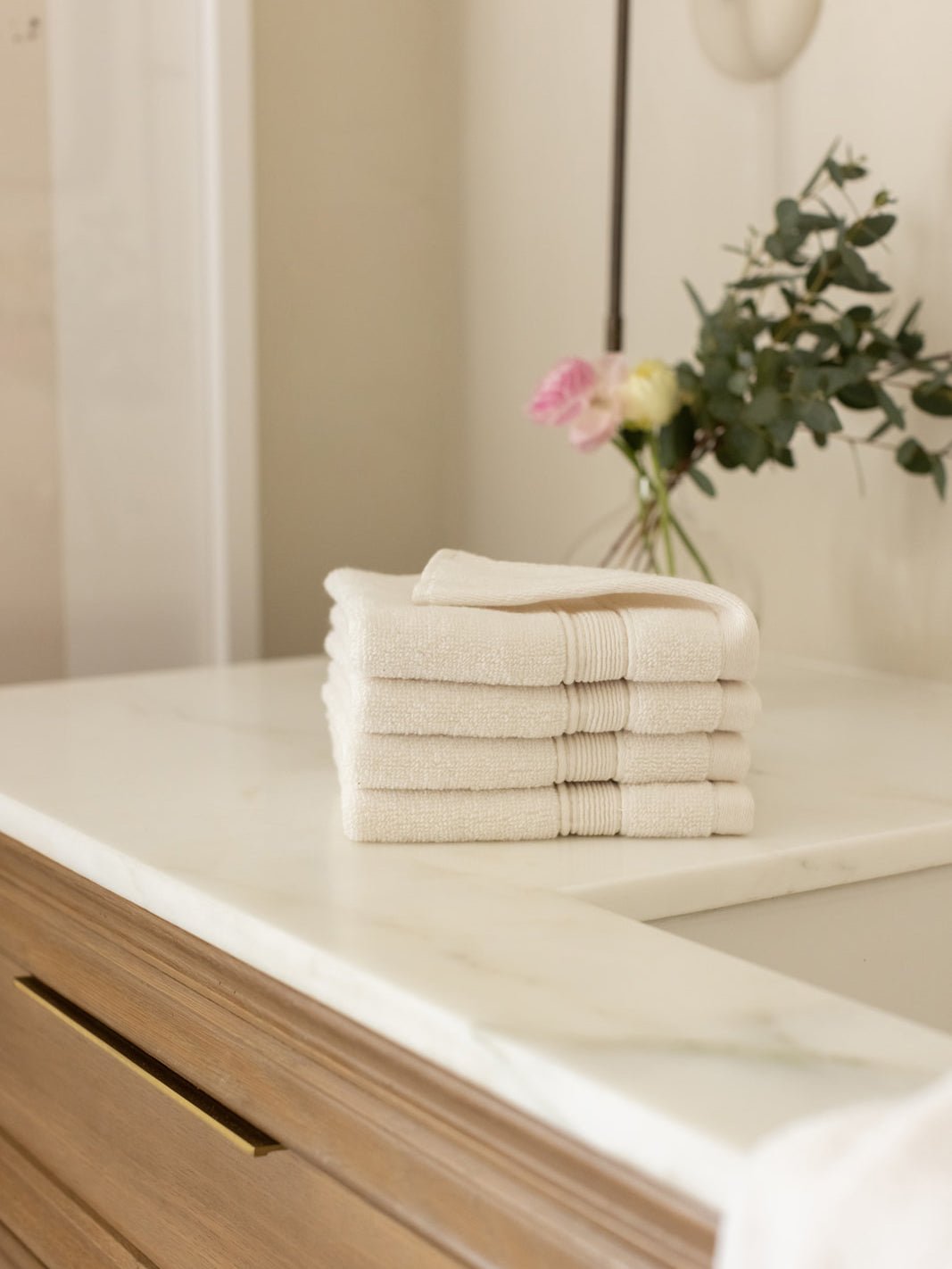 Seashell washcloths folded on bathroom counter 