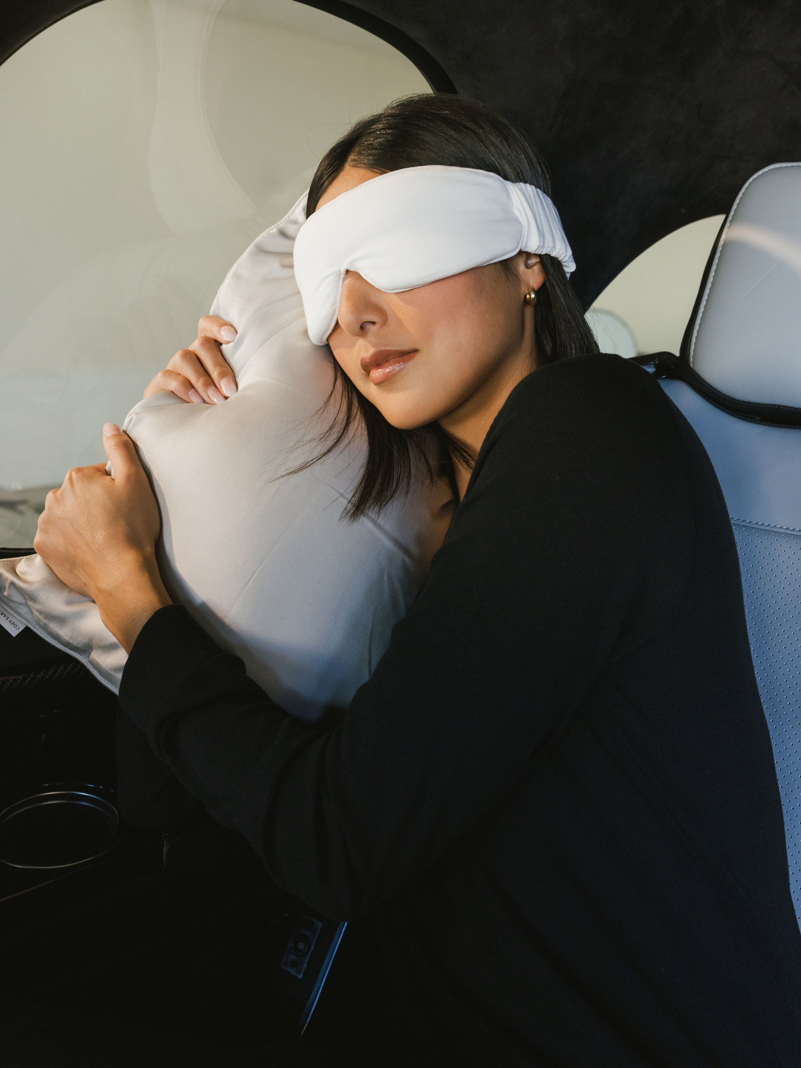 Woman with face mask in airplane using travel pillow 