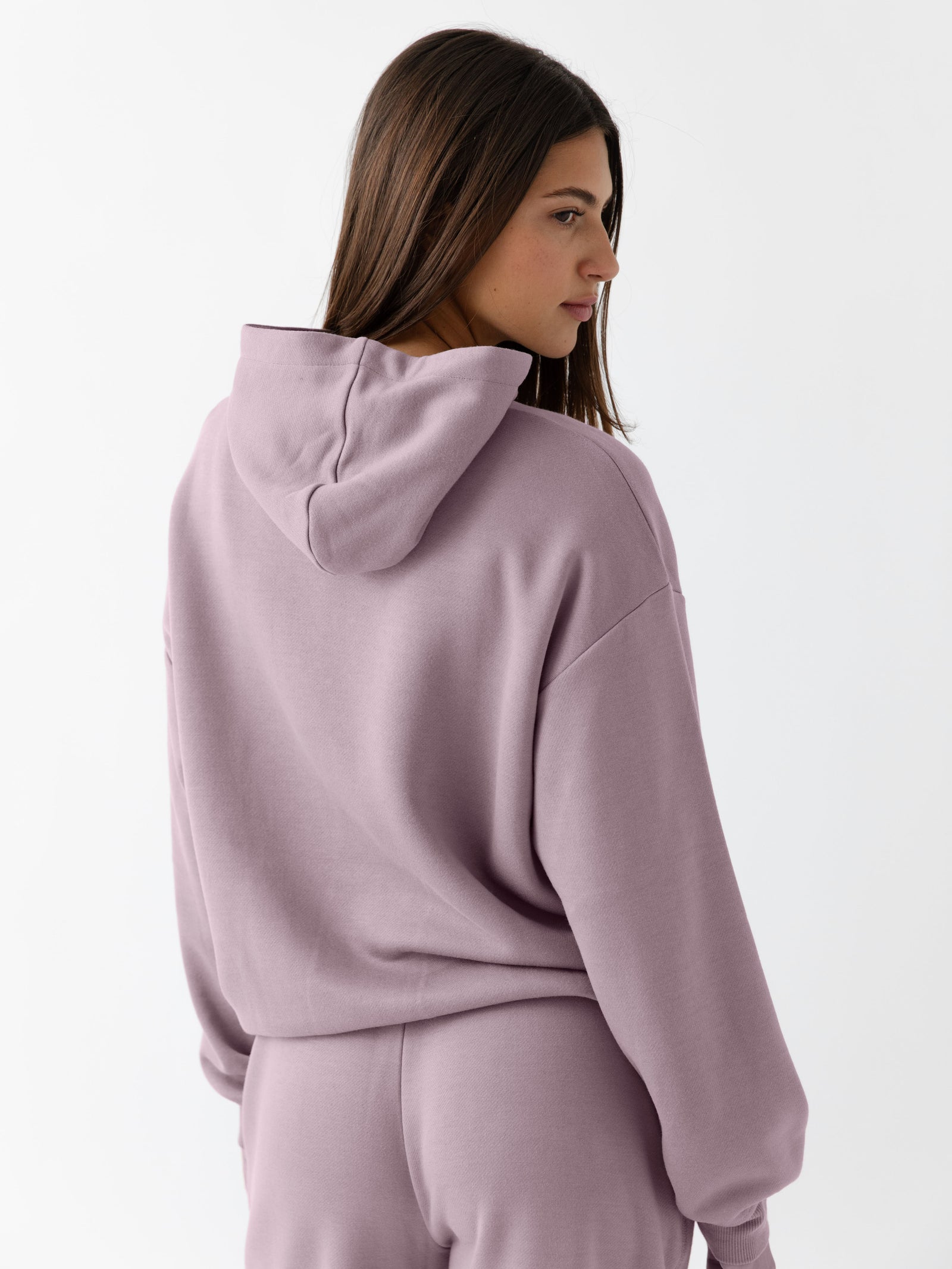 Back of woman wearing dusty orchid cityscape hoodie 