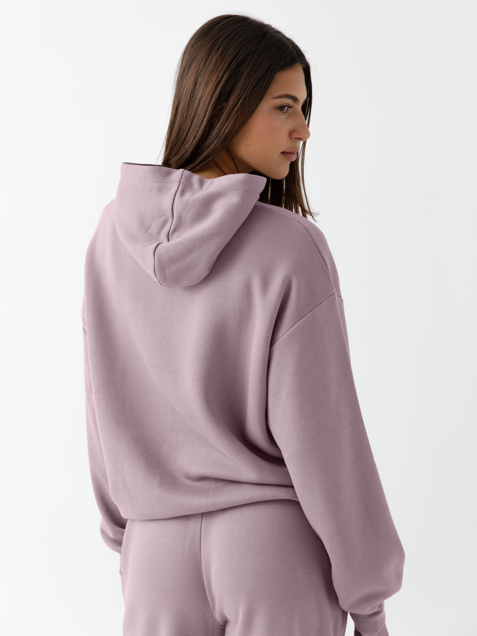 Back of woman wearing dusty orchid cityscape hoodie