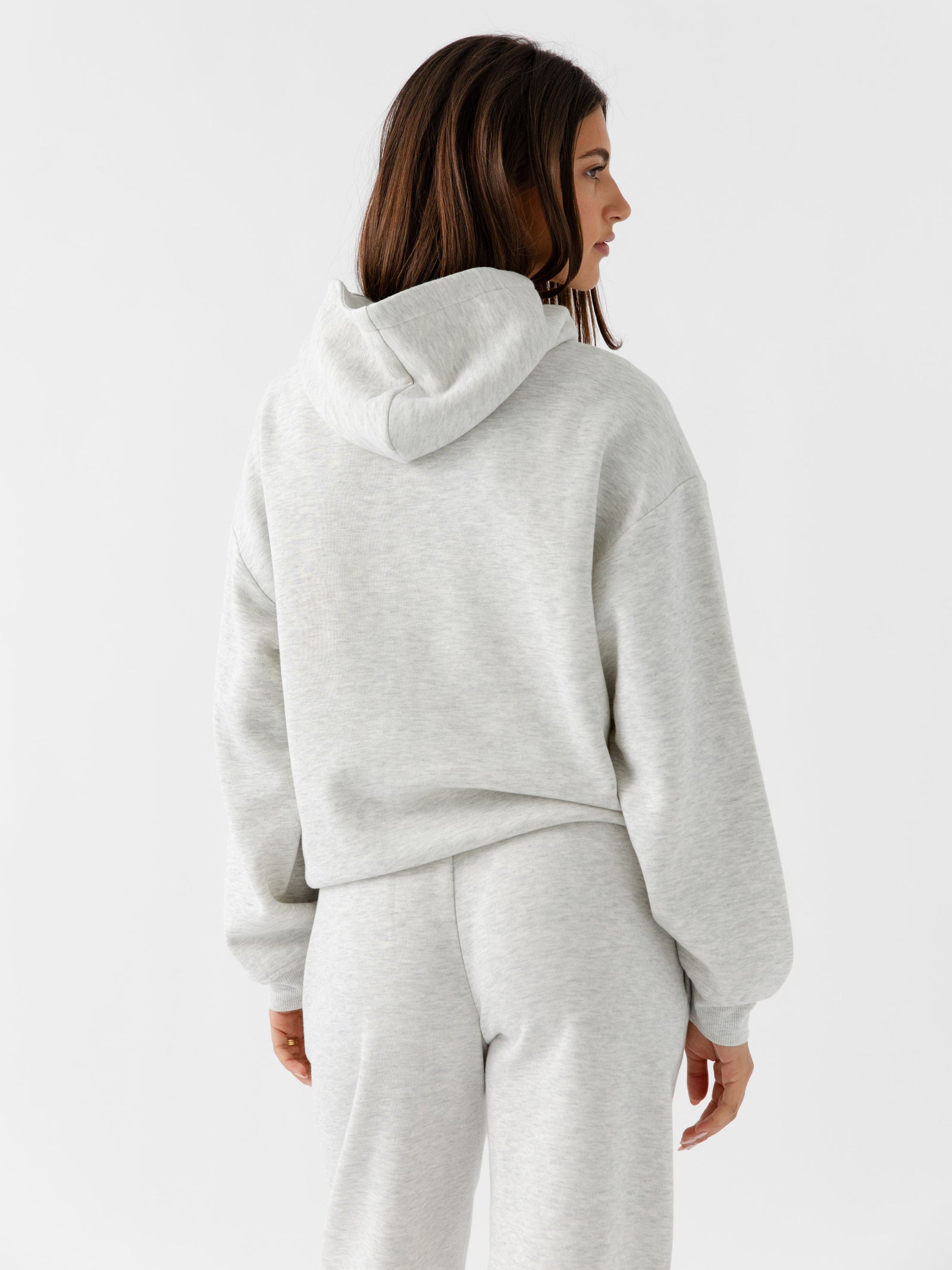 Back of woman wearing heather grey cityscape hoodie 