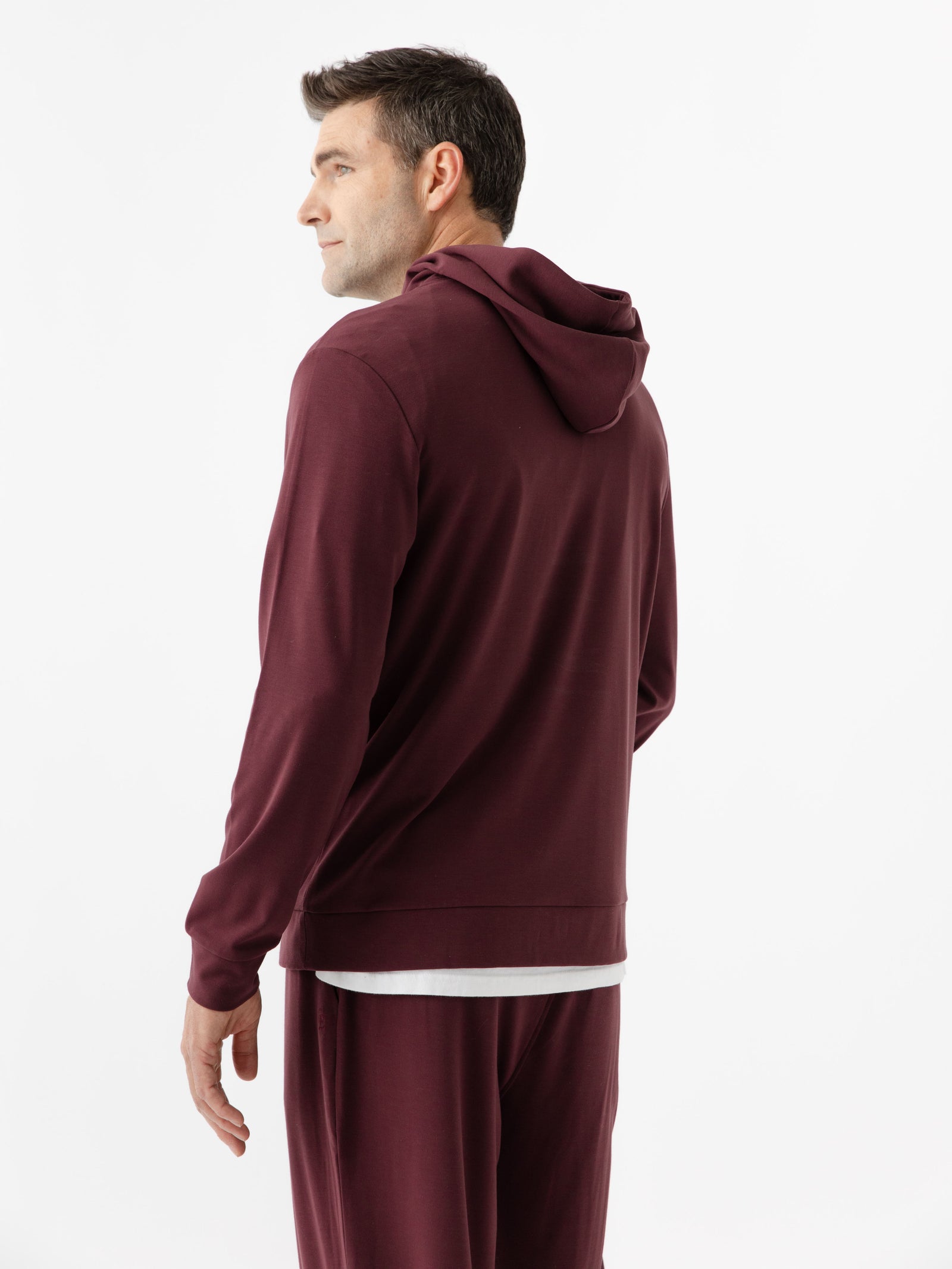 Burgundy Bamboo Hoodie worn by man standing in front of white background with his back facing the camera.
