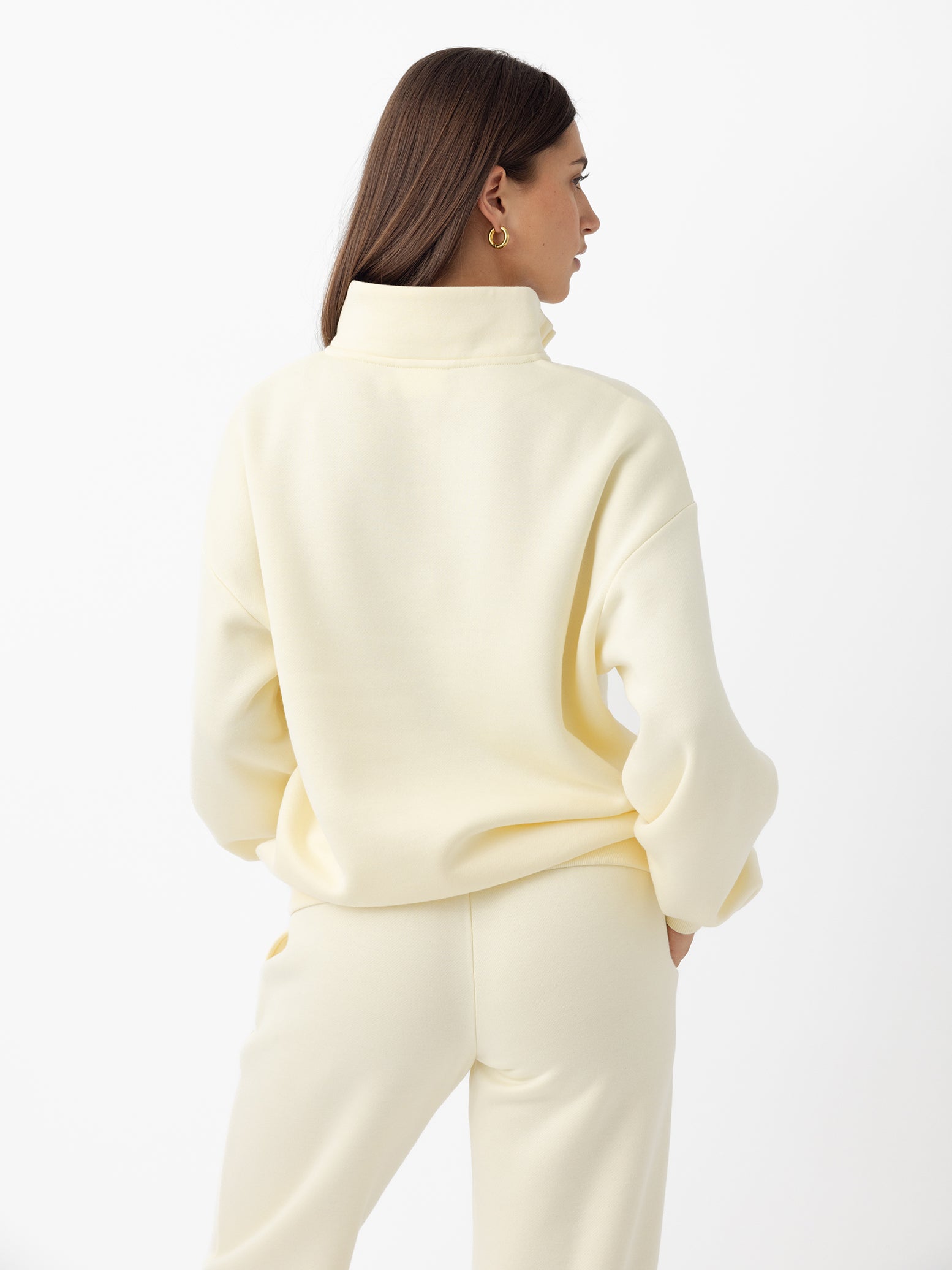 Lemonade CityScape Quarter Zip. The quarter zip is being worn by a female model. The model is wearing accompanying CityScape clothing to complete the look of the quarter zip. The photo was taken with a white background. 