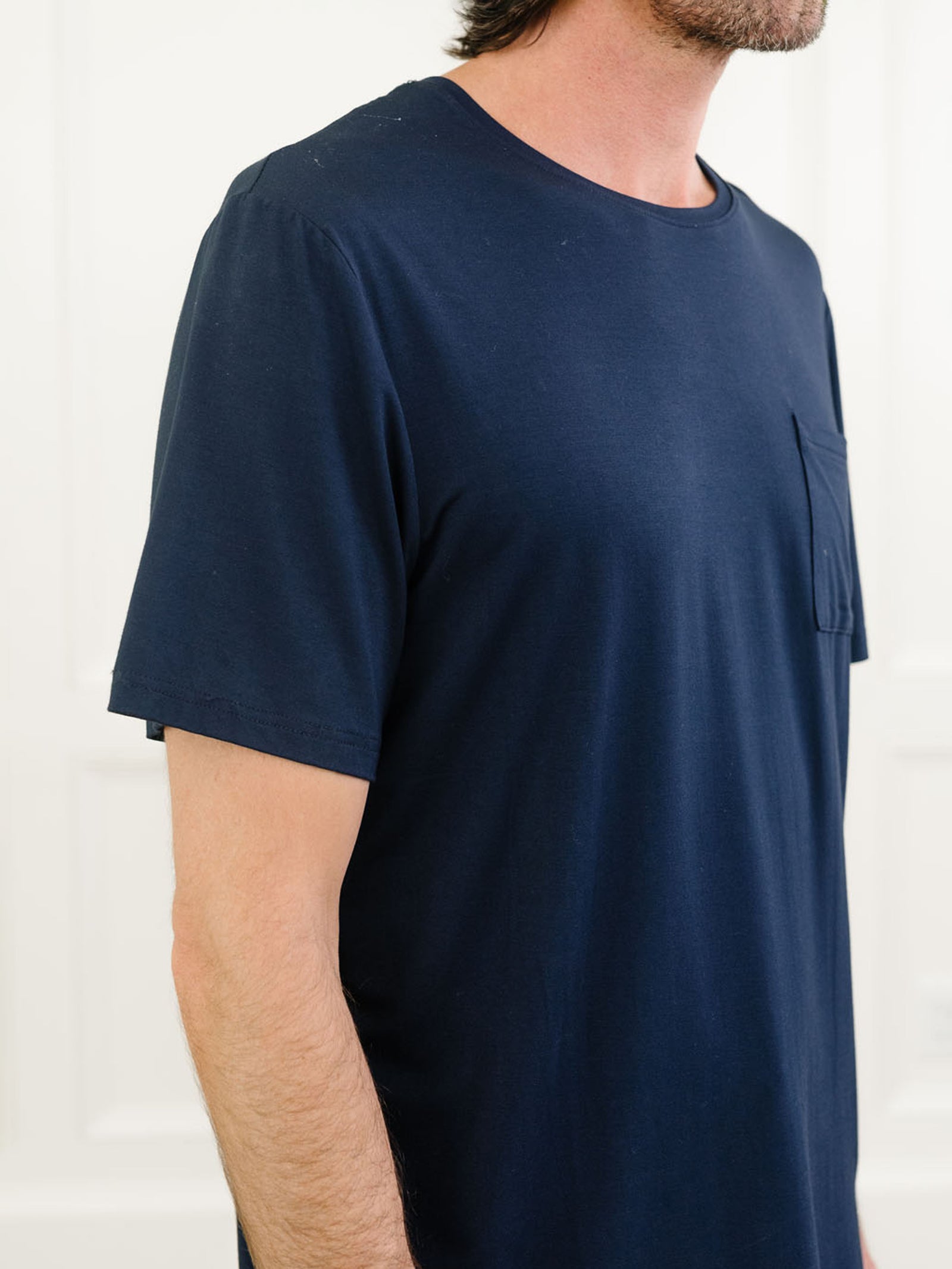 Navy Men's Stretch-Knit Bamboo Lounge Tee. A man is wearing the lounge tee in a well lit home.
