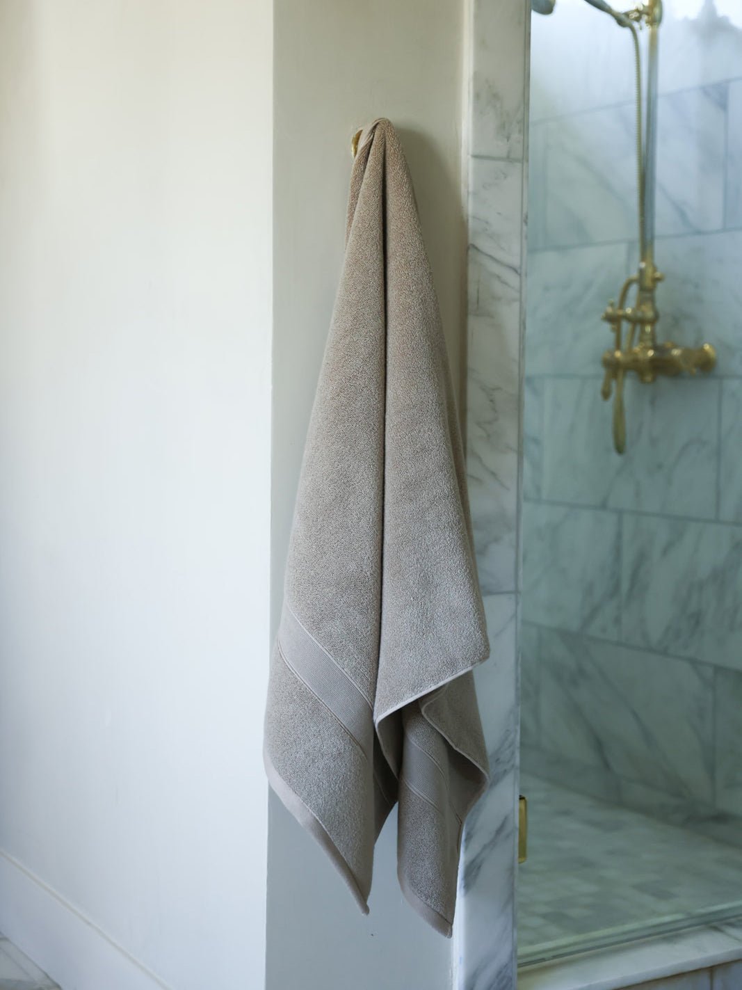 Sand luxe bath sheet hanging next to shower