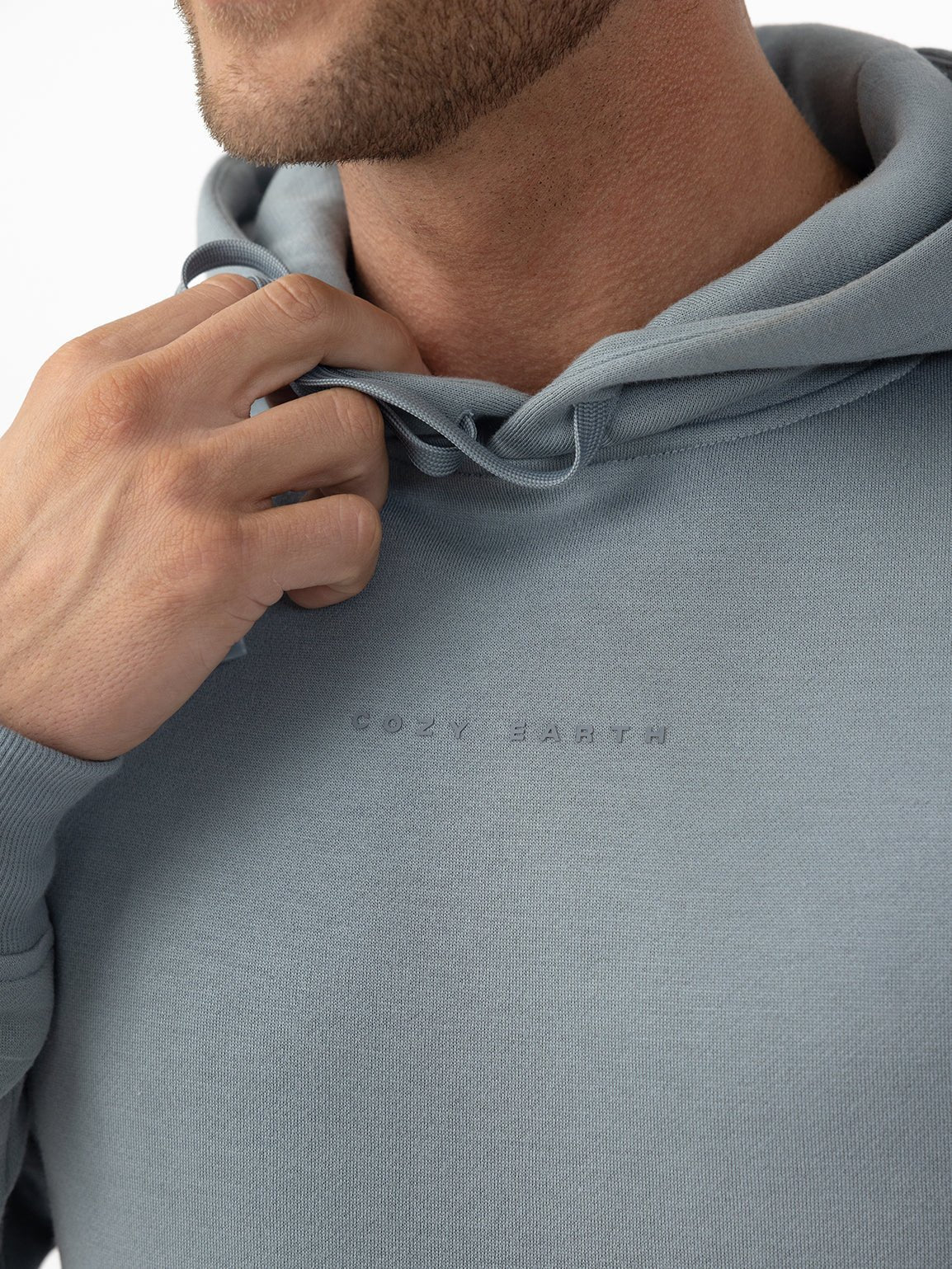 Close up of man wearing smokey blue cityscape hoodie with white background 