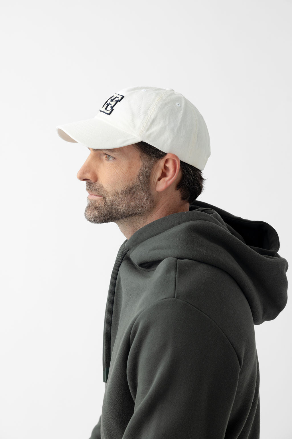 Side view of man wearing washed cream vintage cap 