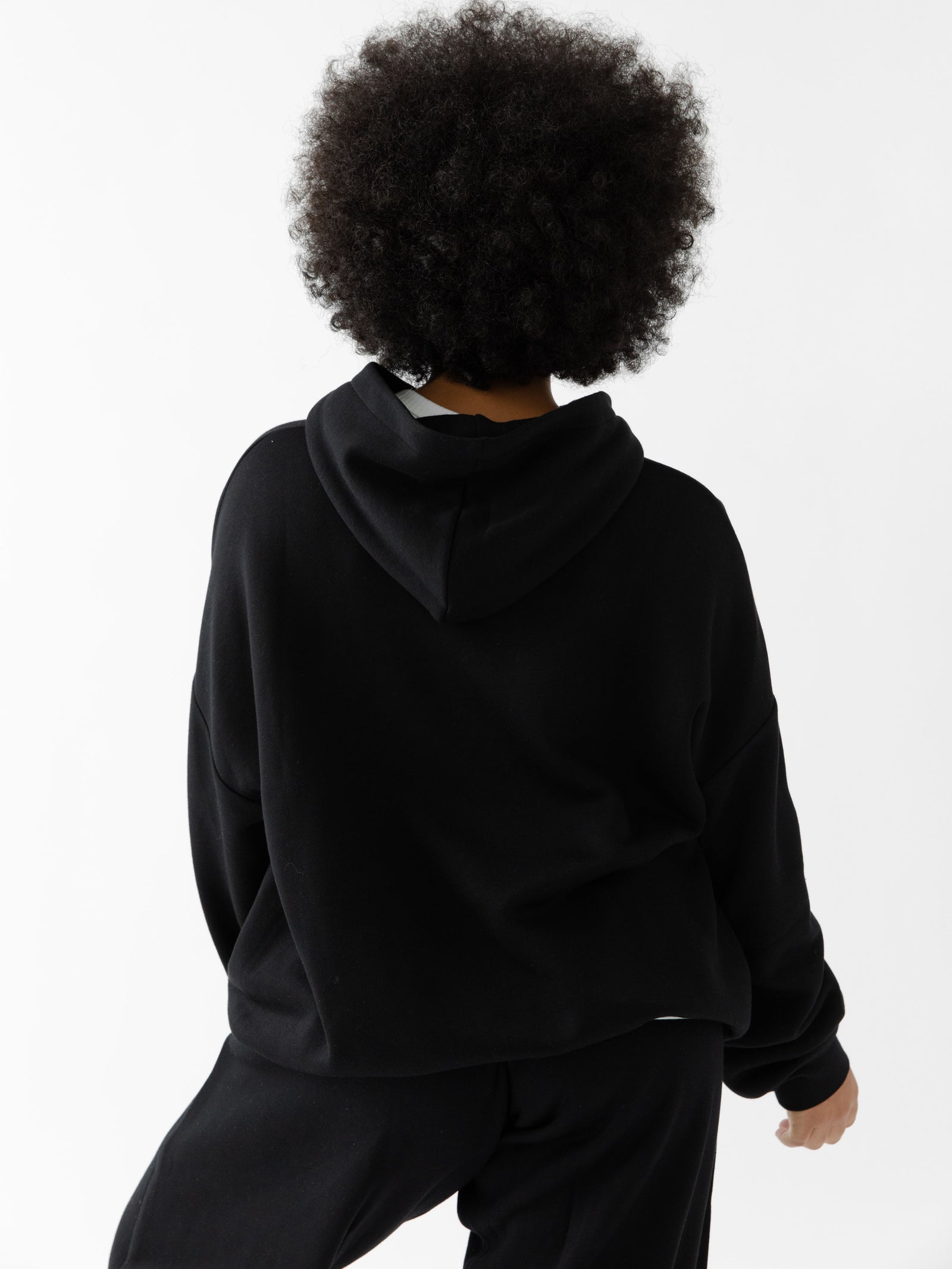 Back of woman wearing black cityscape hoodie 