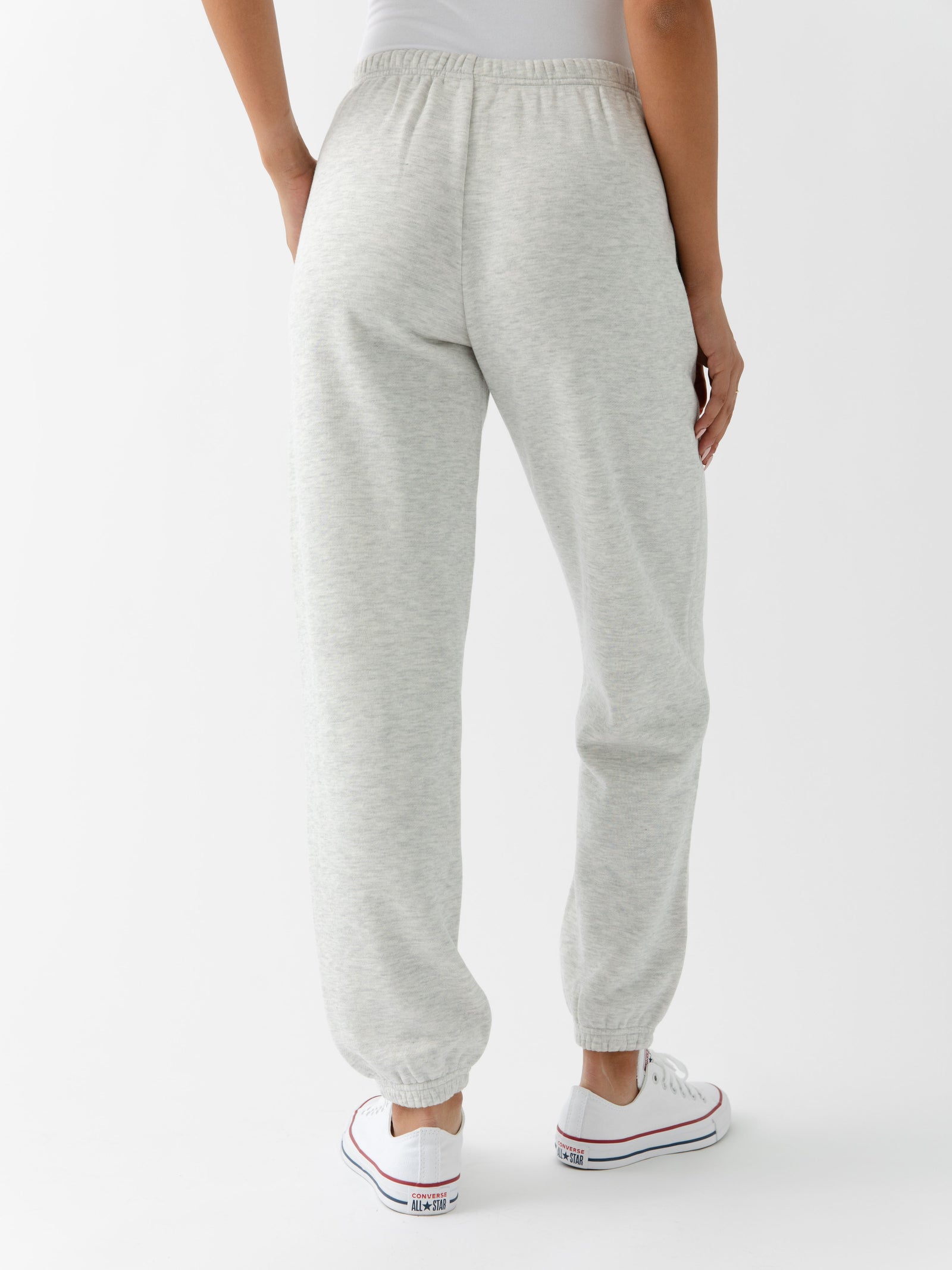 Heather Grey CityScape Joggers. The Joggers are being worn by a female model. The photo is taken from the waist down with the models hand in the pocket of the joggers. The back ground is white.