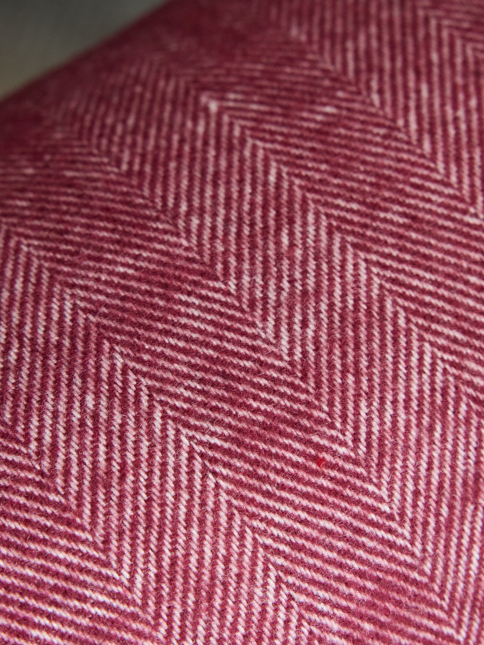 Close up of berry herringbone tassel throw