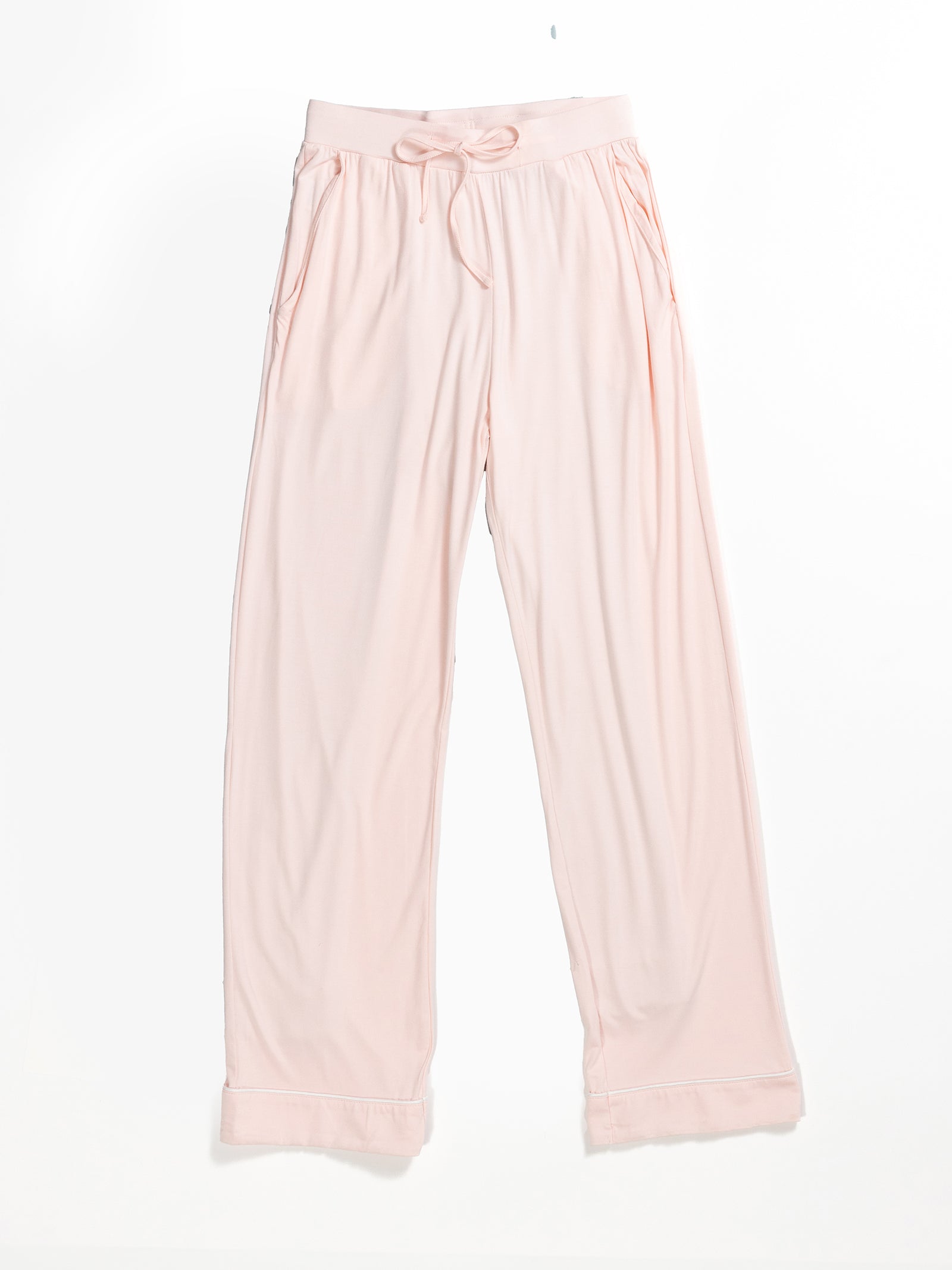 The Women's Stretch-Knit Bamboo Pajama Pant TALL by HIDE features a pair of light pink, soft fabric lounge pants with a drawstring waist and two side pockets. These pants have a relaxed, loose fit with folded hems and are made from smooth, flowy bamboo knit that is perfect for comfortable and casual wear.