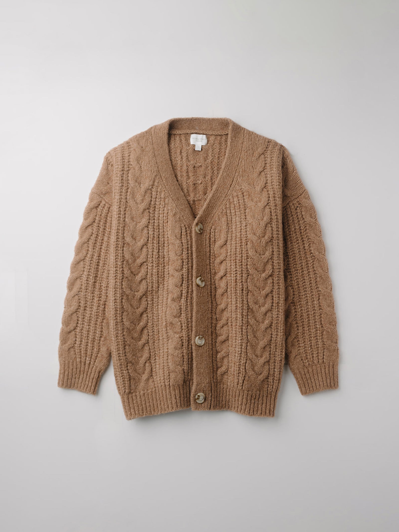 Flay lay of camel cable knit cardigan with white background