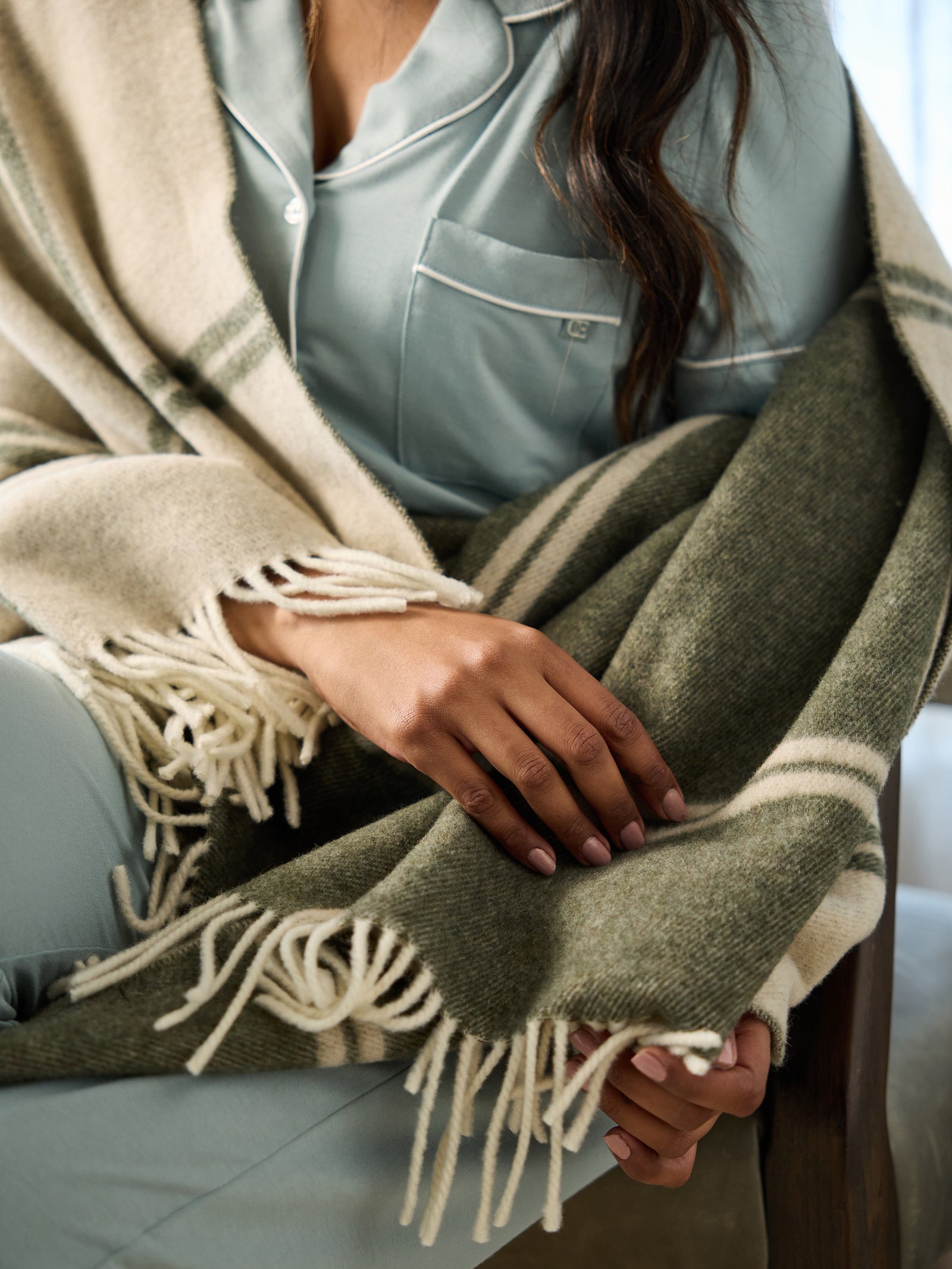 Close up of olive cortina throw rapped around woman