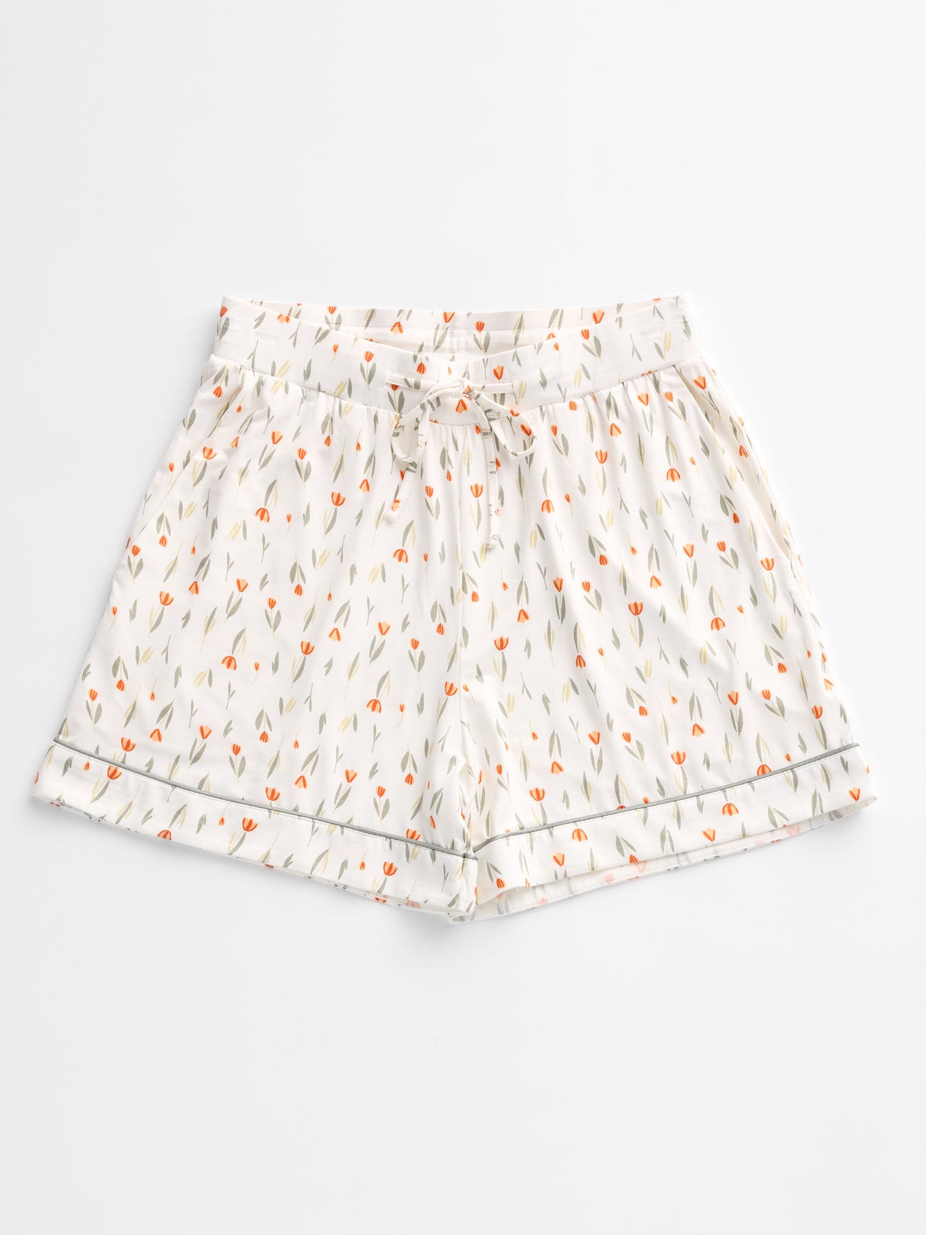 The Women's Bamboo Stretch-Knit Pajama Short by HIDE, featuring a small floral pattern with orange flowers and green leaves, elastic waistband, drawstring, and hem with a subtle decorative border, is laid flat on a plain white background.
