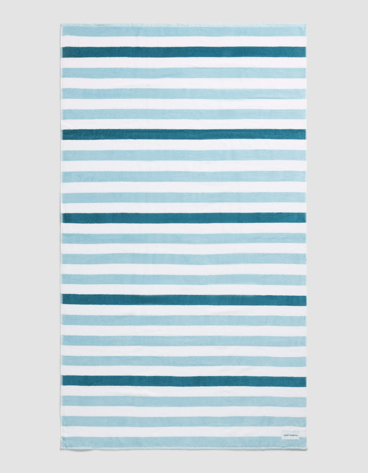 The Cozy Earth Classic Stripe Resort Towel in Lake Stripe features horizontal blue and white stripes of varying thickness and intensity, displayed flat on a neutral background.|Color:Lake Stripe