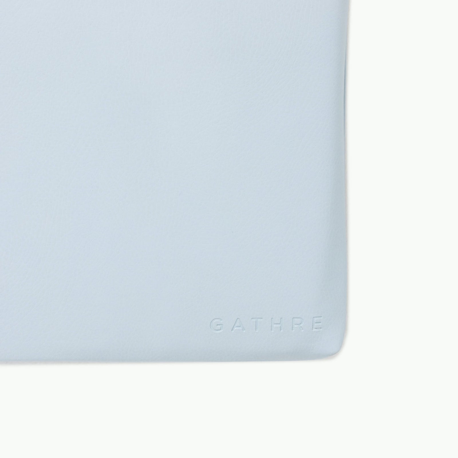 A close-up of the Gathre Wholesale Padded Changing Mat’s light blue leather surface, featuring the brand's name embossed in the lower right corner.