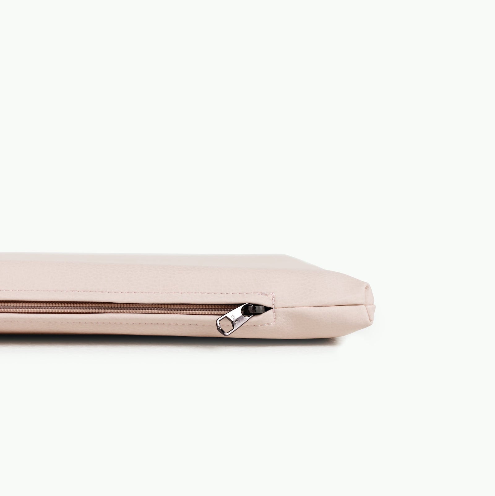 The Gathre Wholesale Padded Changing Mat is shown in light pink, lying flat on a white background with the zipper partially closed and the zipper pull visible.