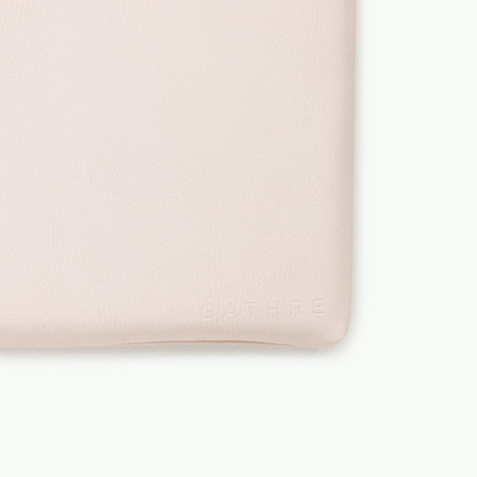 Close-up of the Gathre Wholesale Padded Changing Mat in light beige leather with a subtle texture. "GATHRE" is embossed in small, capital letters near the bottom right corner.