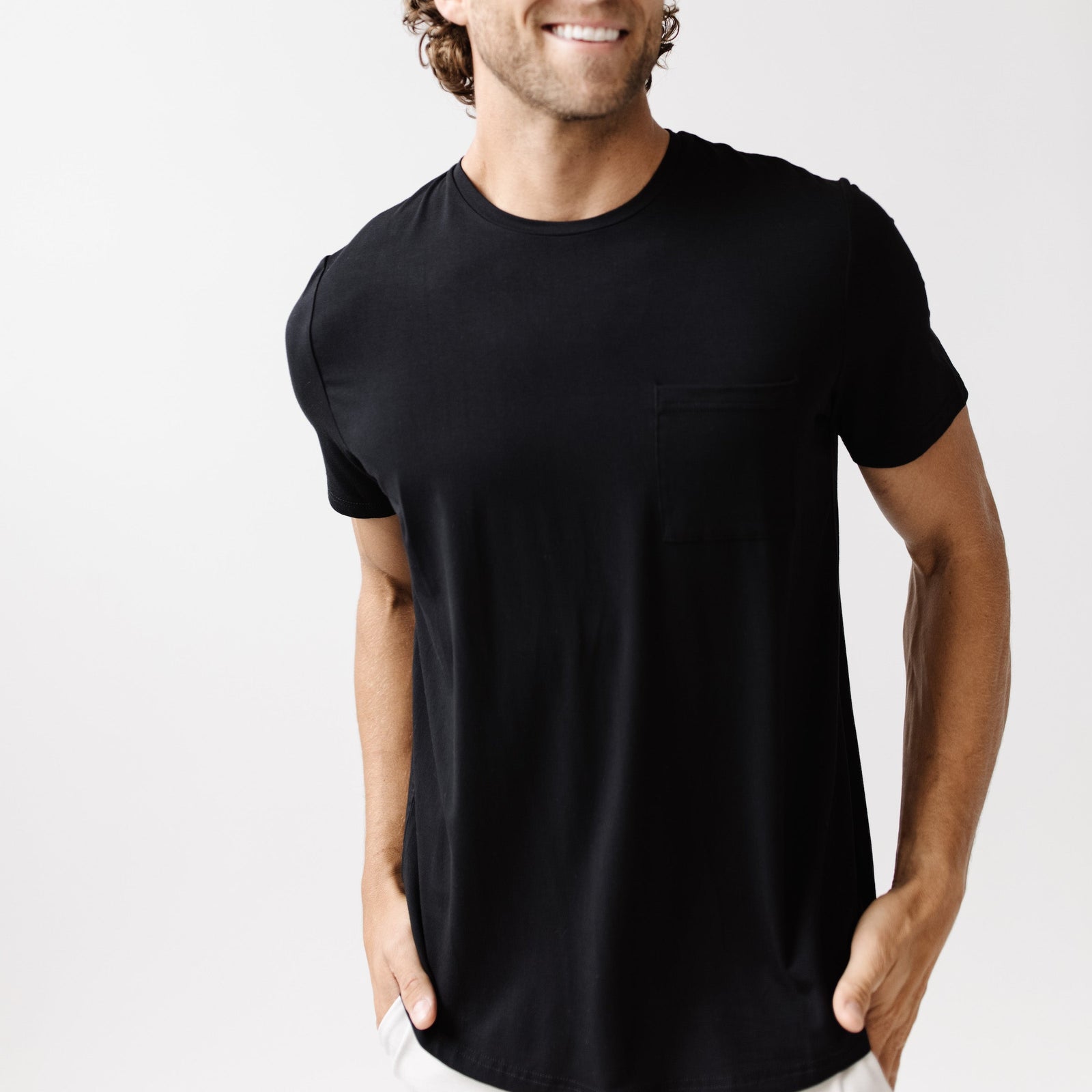 Black Men's Stretch-Knit Bamboo Lounge Tee. A man is wearing the lounge tee in a well lit home.