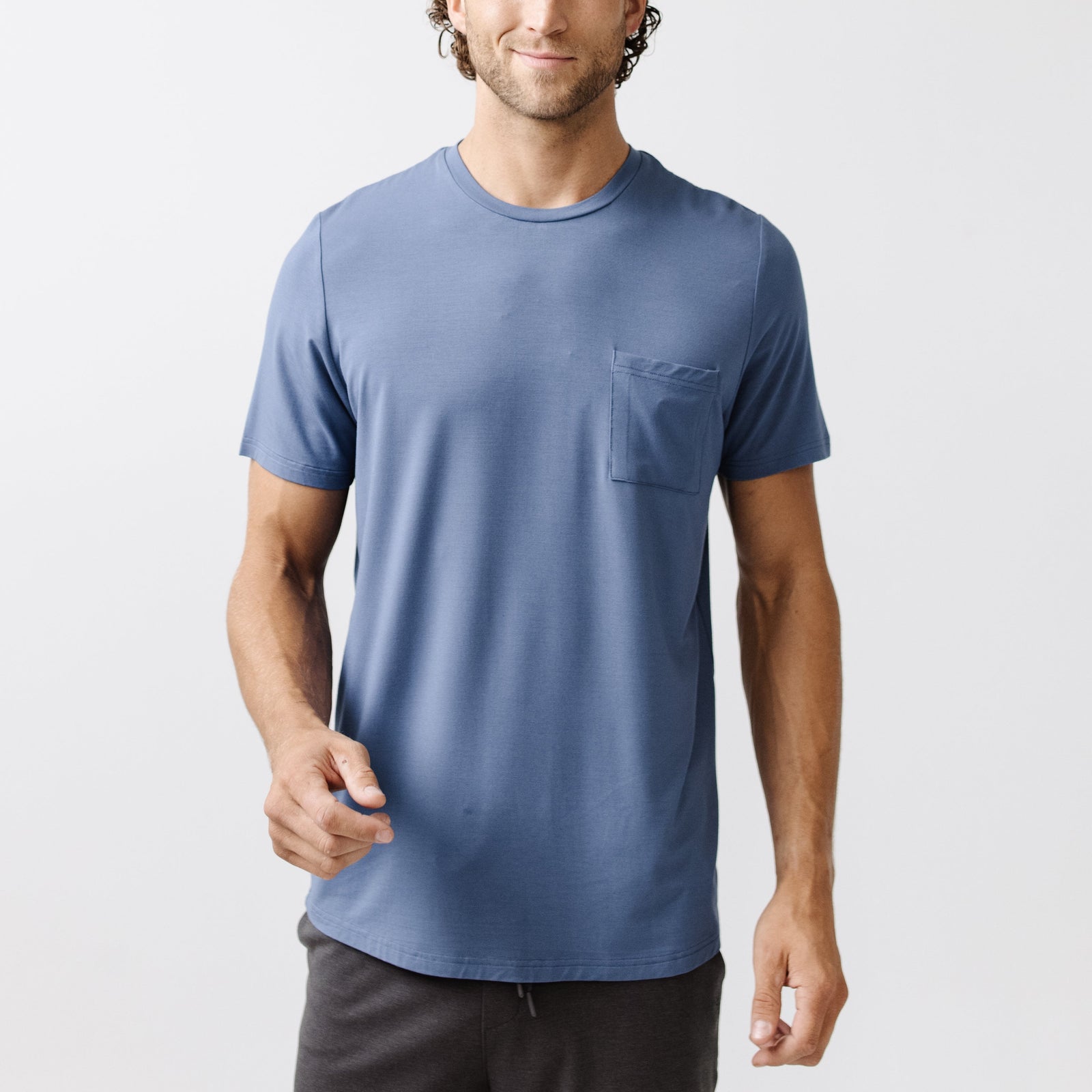 Blue Men's Stretch-Knit Bamboo Lounge Tee. A man is wearing the lounge tee in a well lit home.
