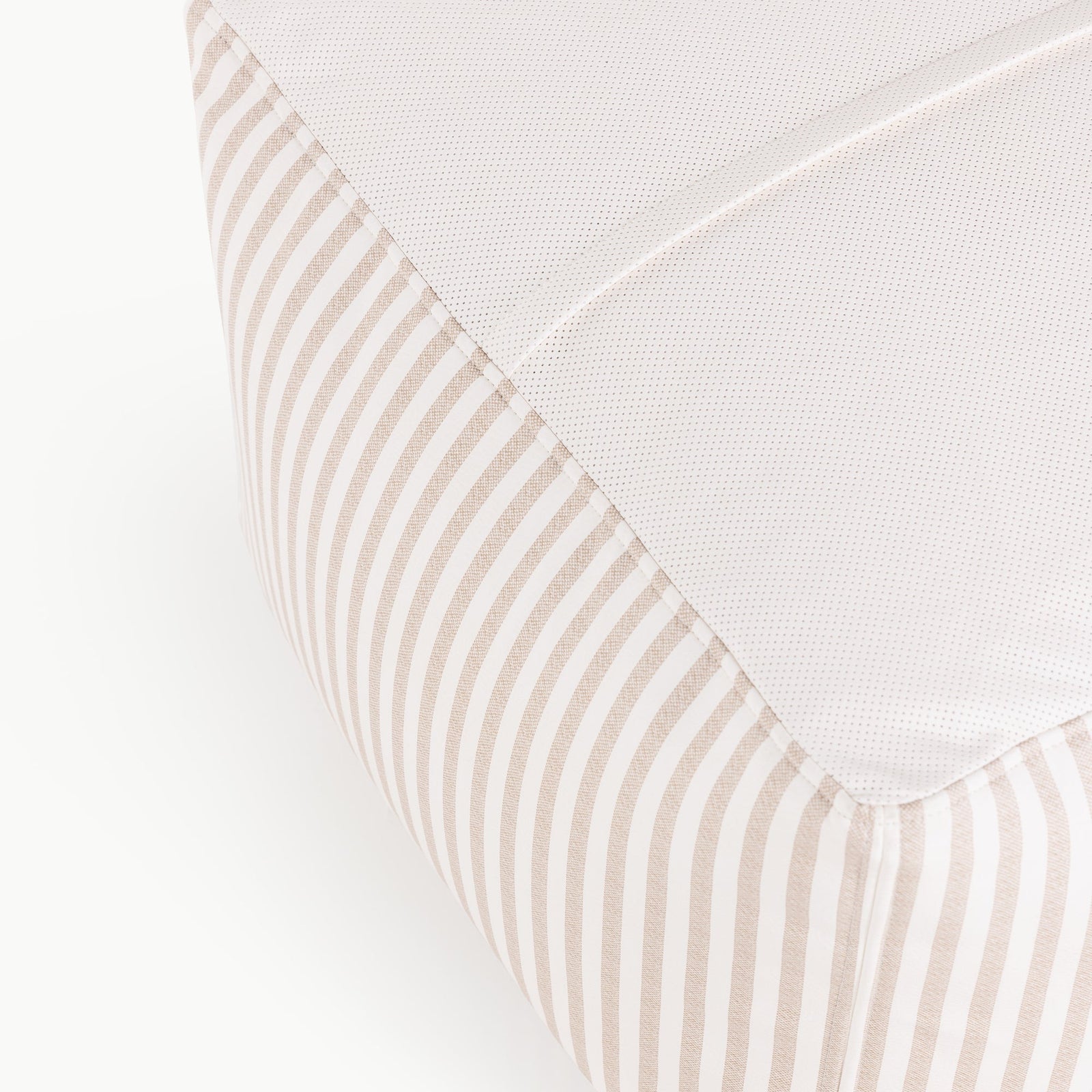 Close-up of the corner of the Wholesale Pouf by Gathre, featuring beige and white vertical striped sides and a textured white top surface.