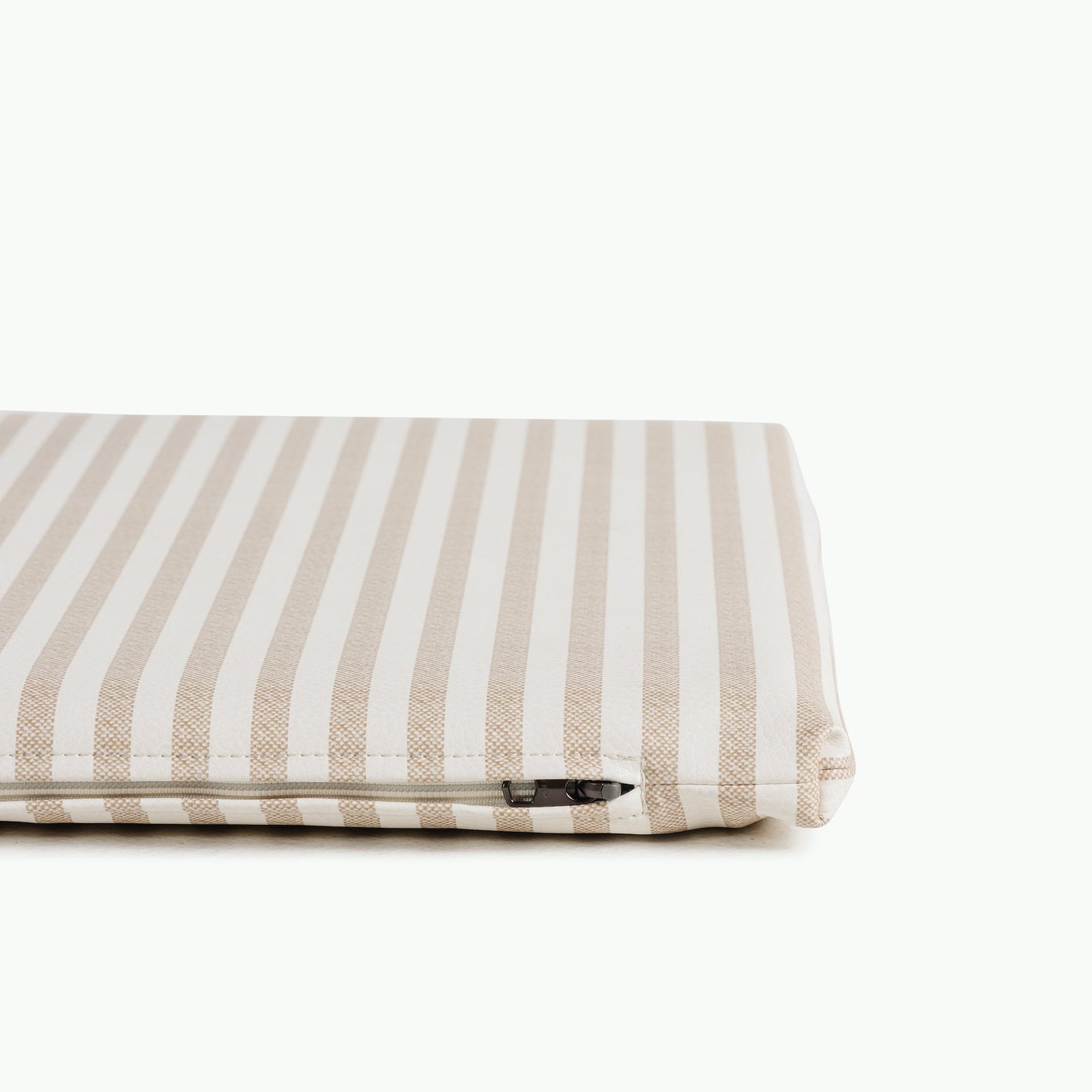 A close-up of the Gathre Wholesale Padded Changing Mat in beige and white stripes, partially shown from the side with a visible zipper, set against a plain white background.