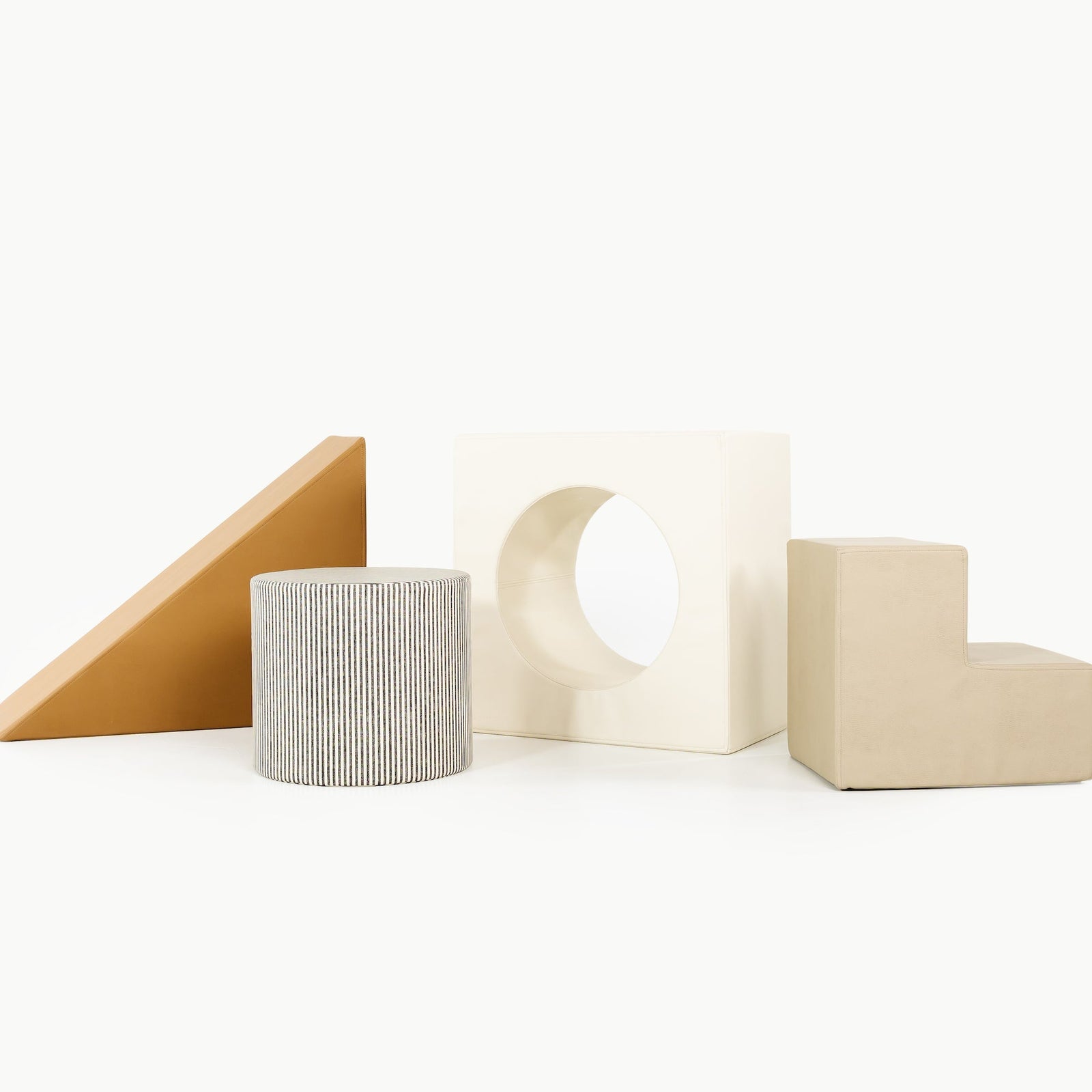 Four geometric foam shapes from the Gathre Wholesale Block Playset in Camel are arranged in a row on a white background.