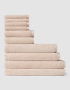 The Complete Ribbed Terry Bath Bundle by Cozy Earth features beige towels in multiple sizes, stacked neatly in a step formation against a plain white background.|Color:Petal