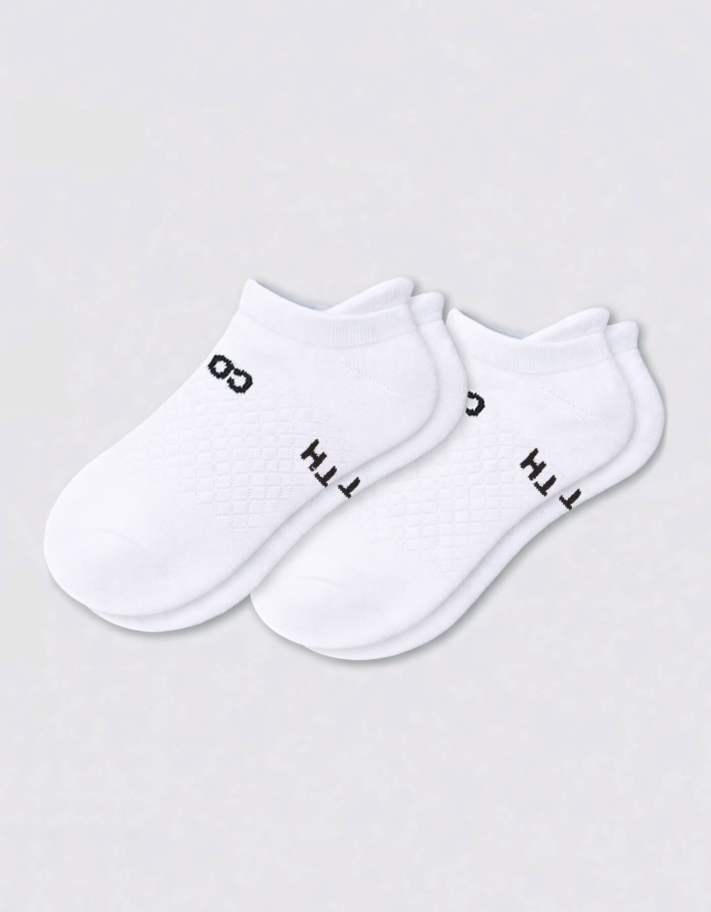 The Women's Essential Ankle Sock by Cozy Earth features a textured white design with subtle black text near the cuff, shown on a light gray background.|Color:White