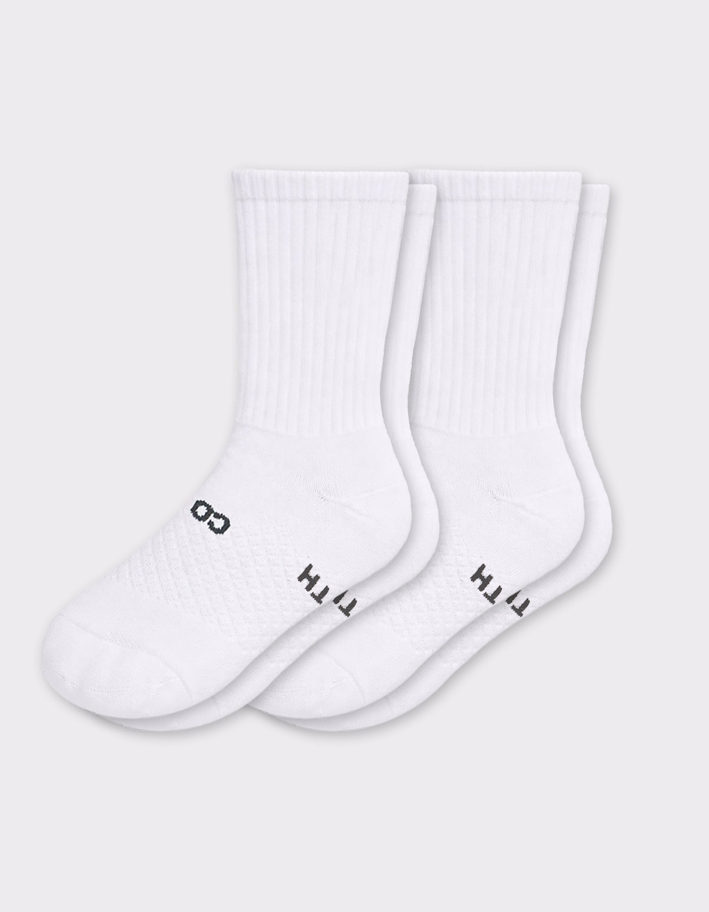 Two pairs of Cozy Earth Women's Essential Calf Socks in white, featuring ribbed cuffs and small black lettering on the soles, are laid side by side on a light gray background.