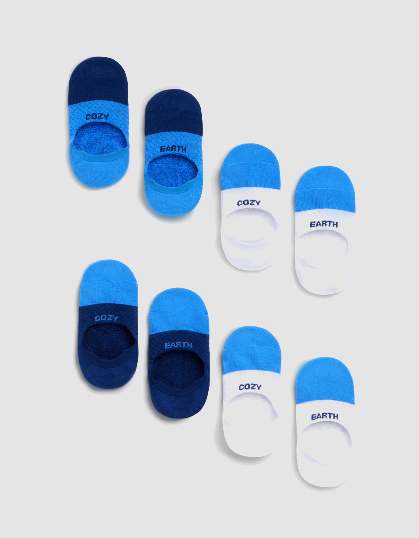 Eight pairs (two Essential No-Show Sock 4-Packs by Cozy Earth) in blue and white, each featuring "COZY" or "EARTH," are neatly arranged on a light gray background.