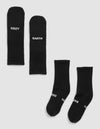 Four Essential Calf Socks by Cozy Earth in black are on a light background—two laid flat display "COZY" and "EARTH" in white, while two others are side by side with partial text visible. |Color:Black