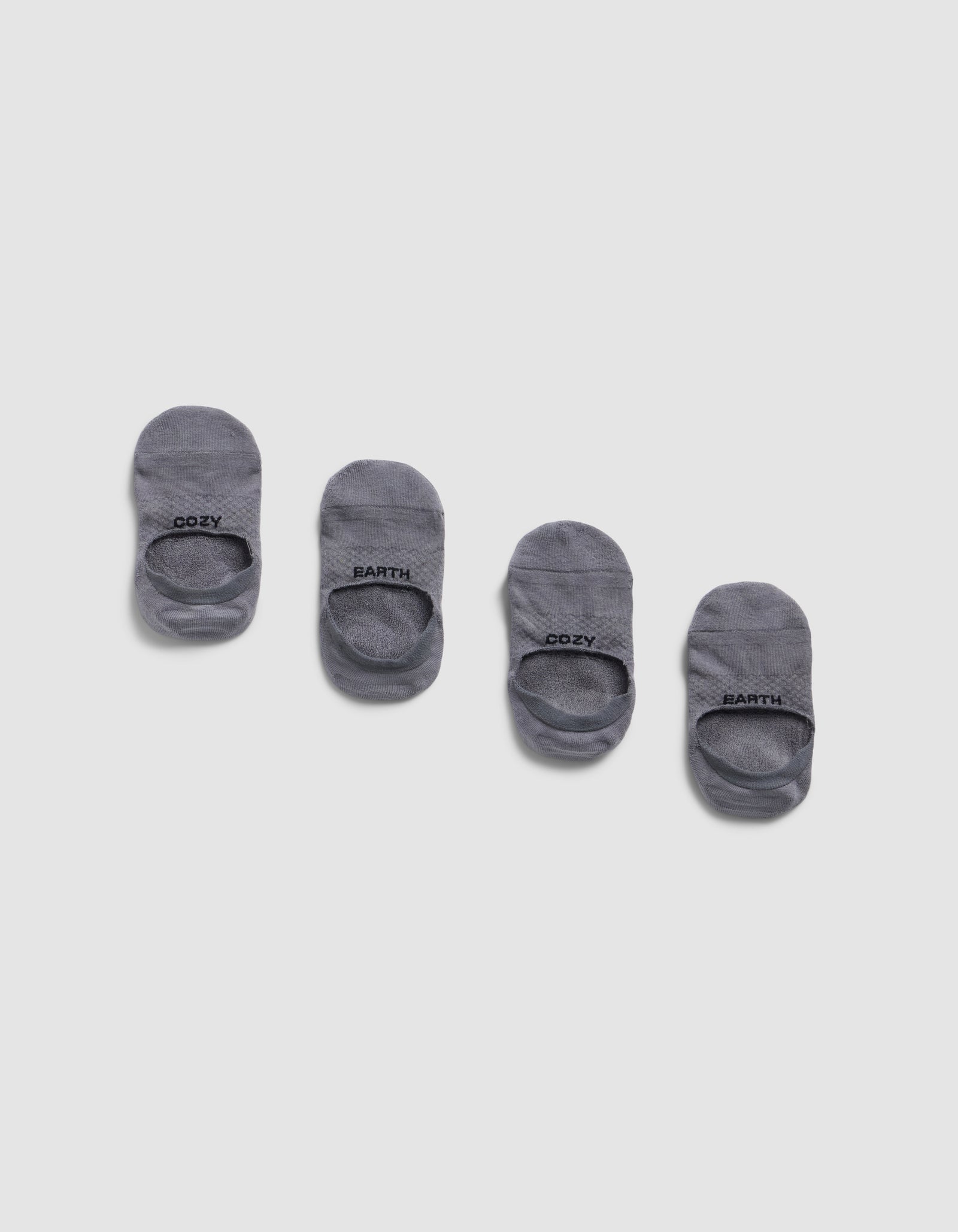 Four pairs of Cozy Earth Essential No-Show Socks are arranged in a row on a light gray background, each displaying "COZY EARTH" in black text near the opening.