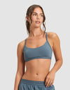 A woman with wavy brown hair in a ponytail wears the Cozy Earth Women's First Layer Pajama Soft Bra and matching shorts, looking to the side against a plain light gray background.|Color:Dawn