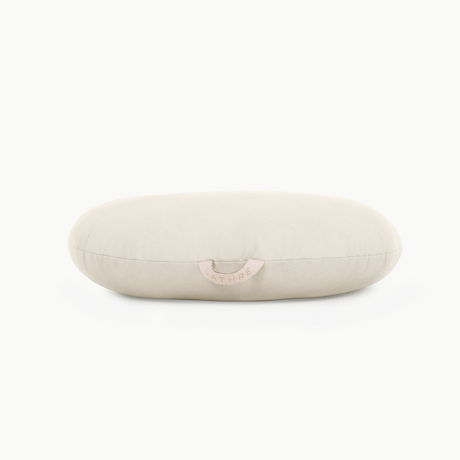 A light beige, oval-shaped Wholesale Floor Cushion by Gathre features a small tan fabric tag on the front, shown against a plain white background.