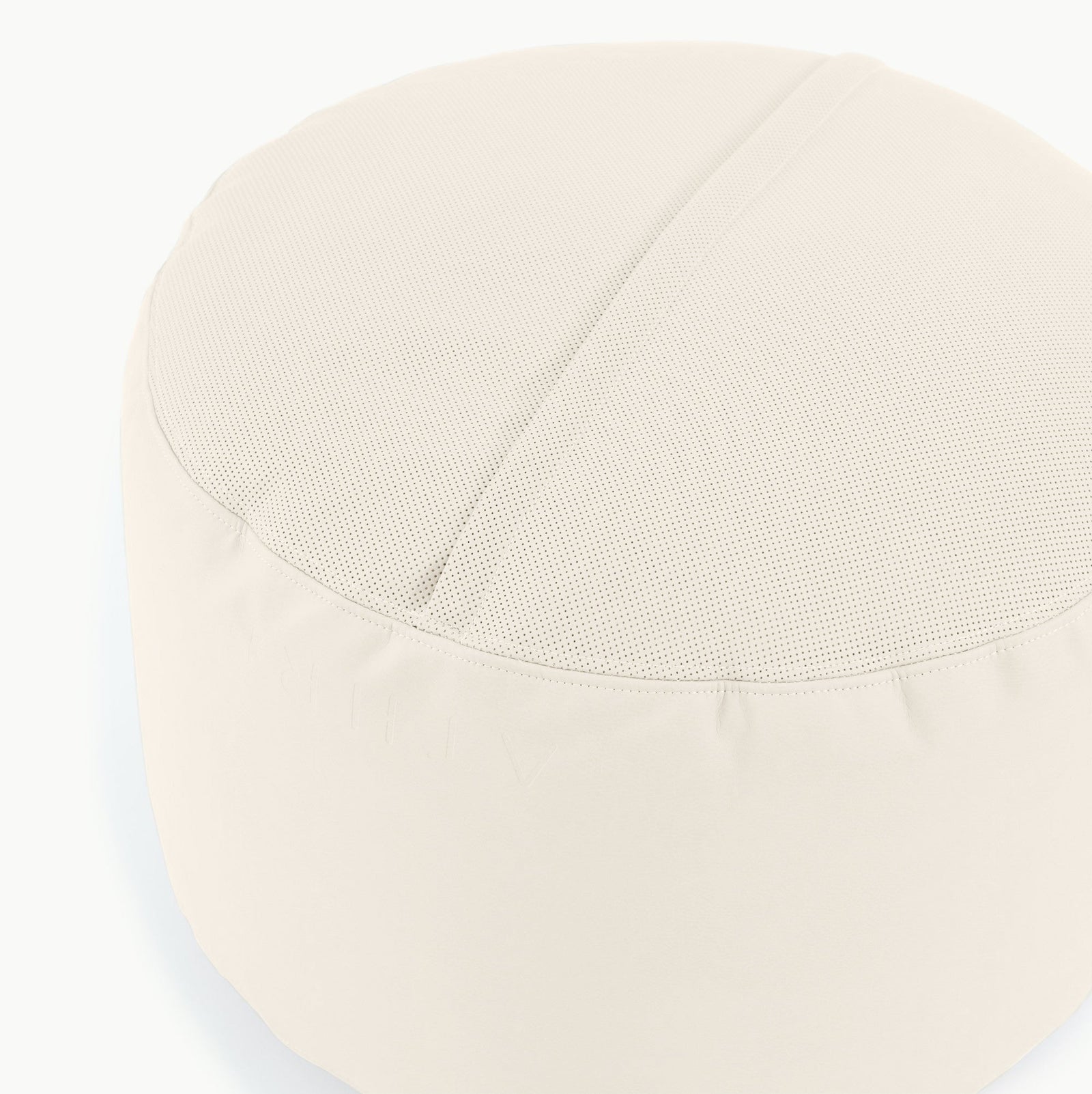 The Gathre Wholesale Pouf is a round, light beige ottoman with a smooth fabric side, a textured top, and a central seam across the surface.