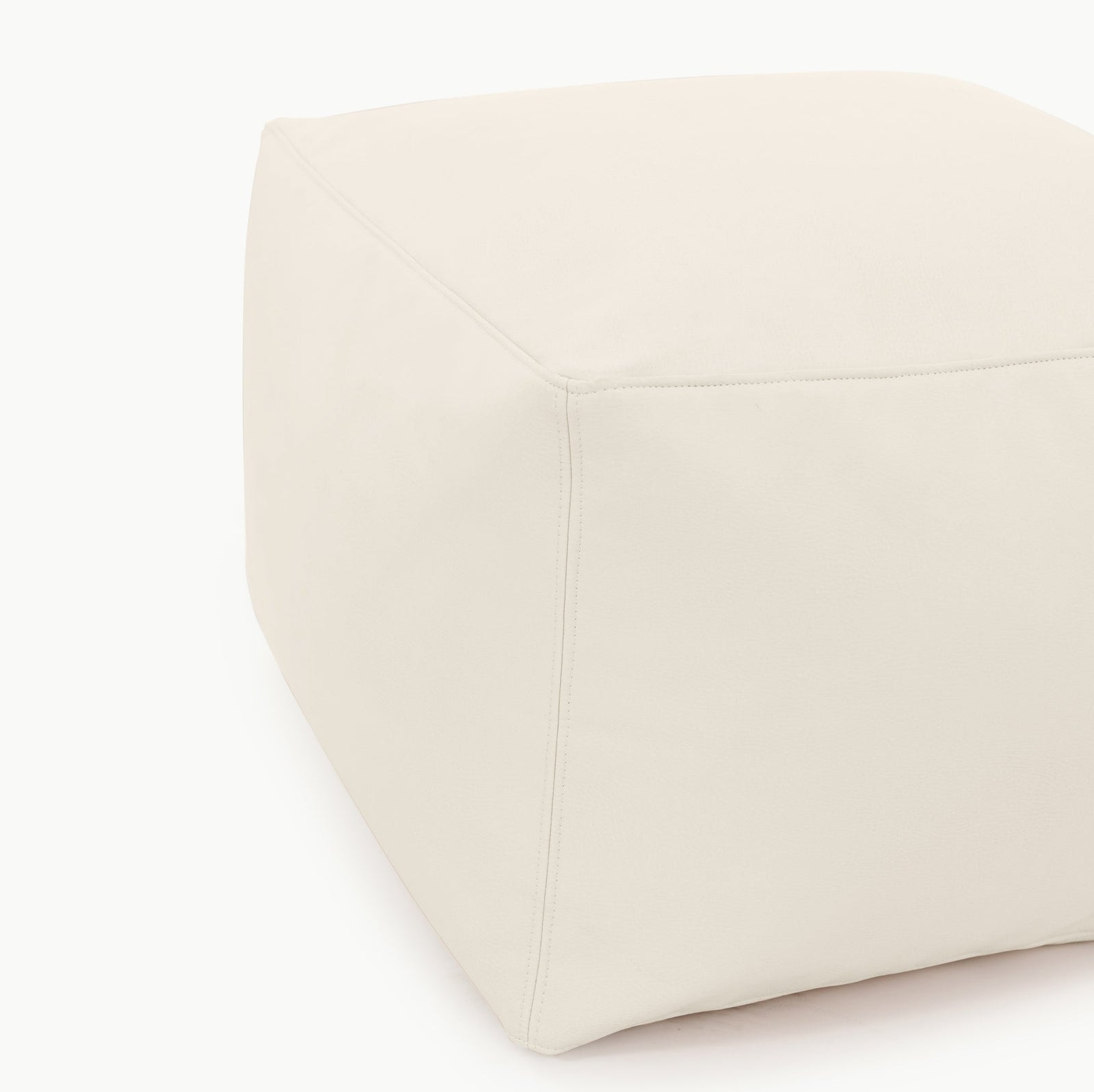 The Gathre Wholesale Pouf is a large, cube-shaped ottoman in light beige with smooth fabric, visible seams, and is displayed against a plain white background.