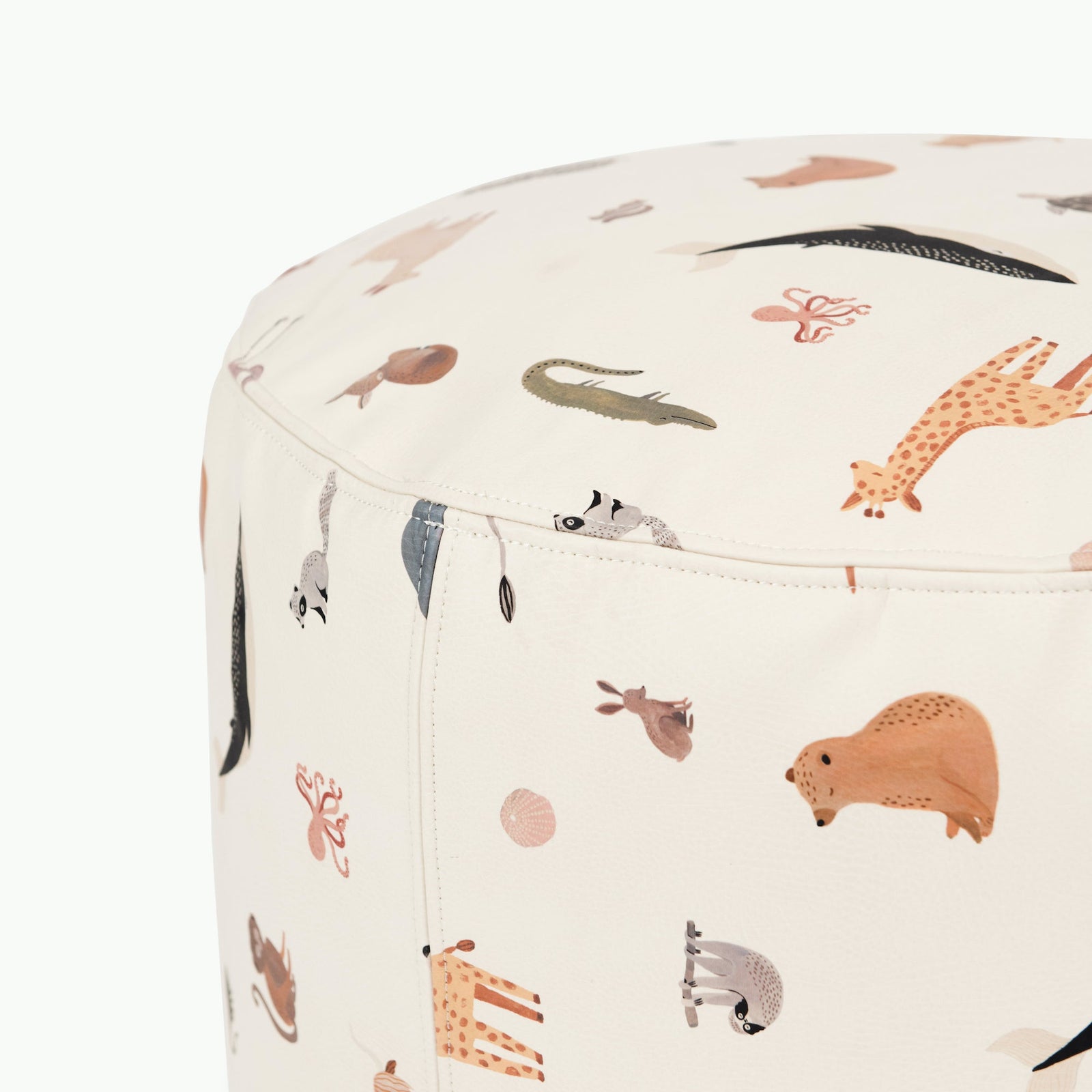 A close-up of the Gathre Wholesale Pouf, a cream ottoman adorned with playful, colorful animal illustrations—crocodile, giraffe, sloth, beaver, and raccoon—on smooth fabric.