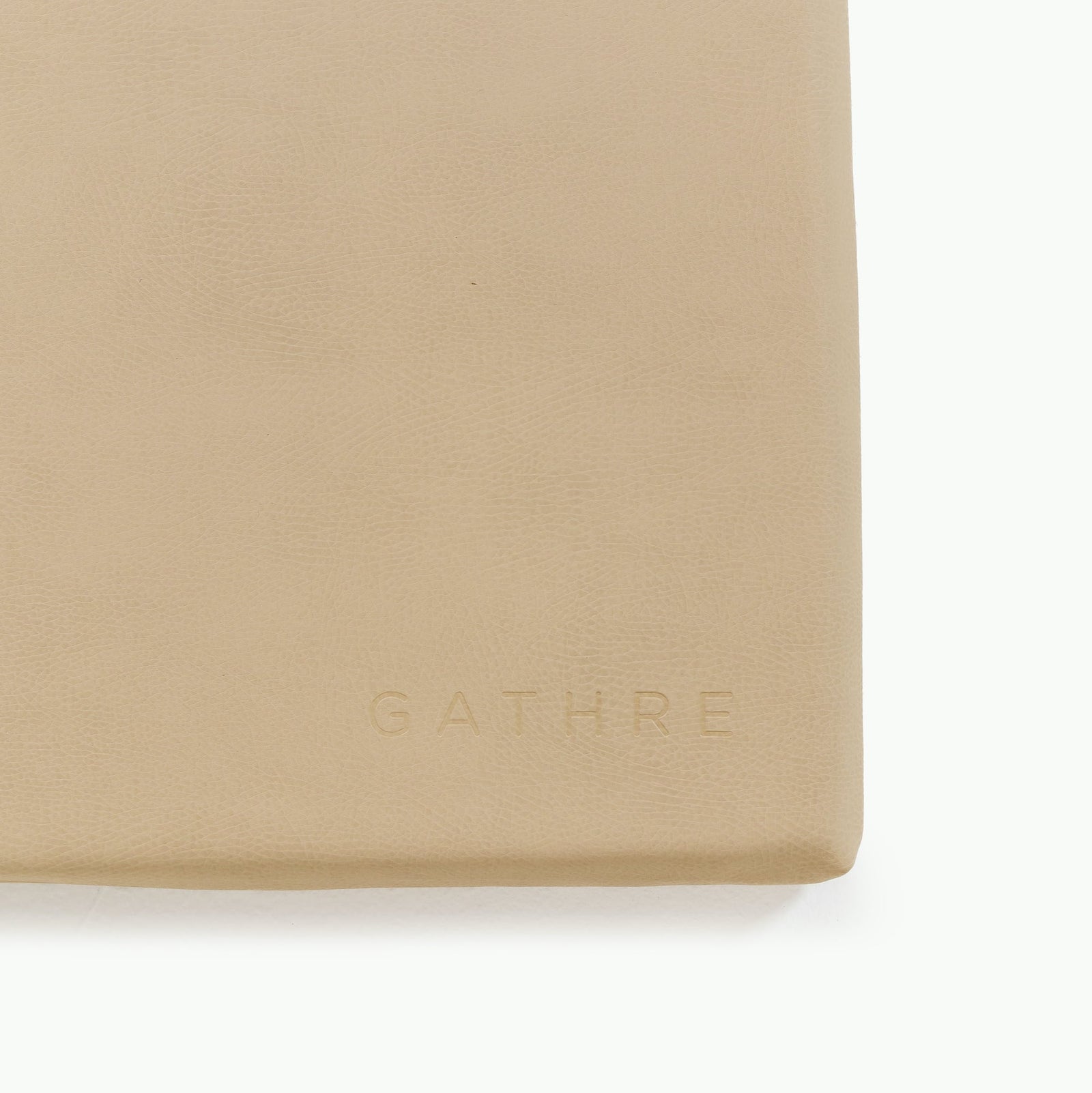 A close-up of the beige, textured Wholesale Padded Changing Mat by Gathre, with "GATHRE" subtly embossed in the lower right corner.