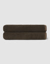 Two neatly rolled dark brown towels from the Cozy Earth Complete Ribbed Terry Bath Bundle are stacked on top of each other against a plain, light background.|Color:Espresso