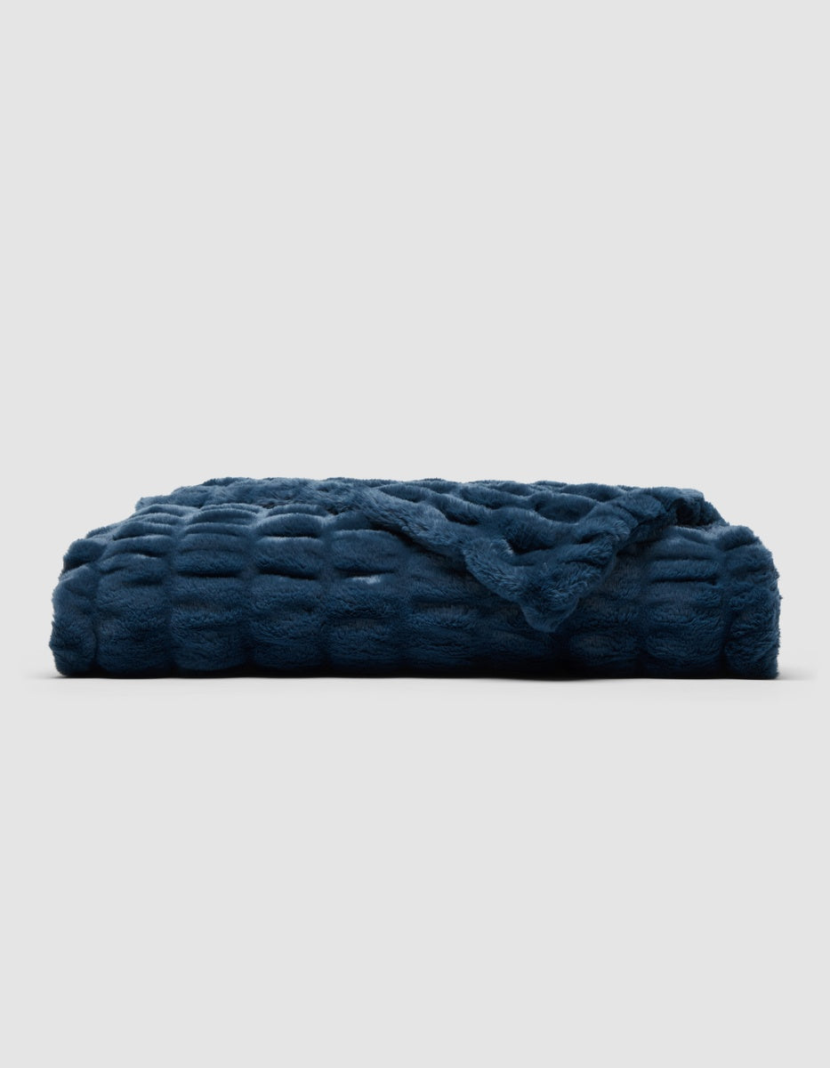 A folded, dark blue textured Cozy Earth Snuggle Cuddle Blanket.|Color:Fathom