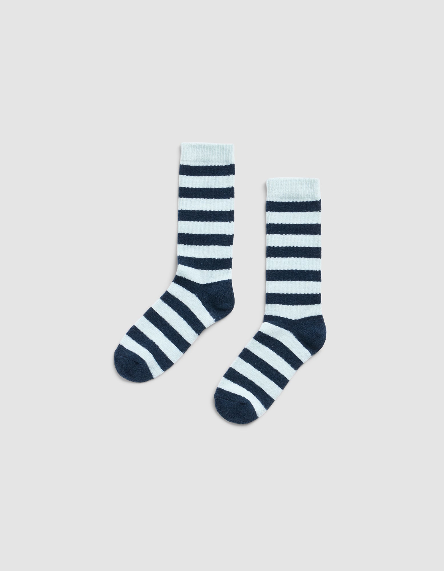 The Striped Plush Lounge Sock by Cozy Earth, featuring horizontal black and white stripes, is shown side by side on a plain light gray background.