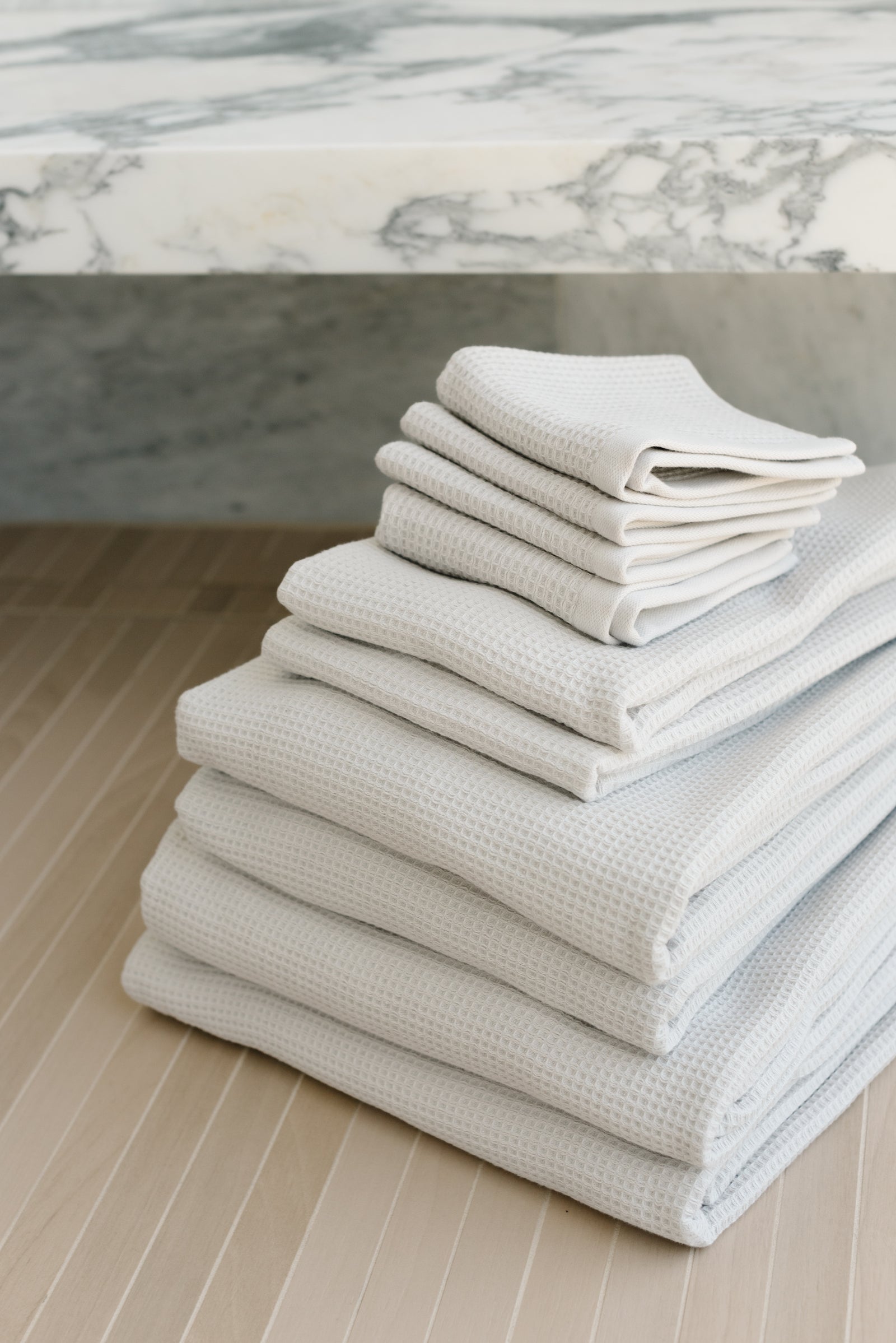 Complete Waffle Bath Bundle in the color Light Grey. Photo of Light Grey Complete Waffle Bath Bundle taken resting on floor of bathroom.