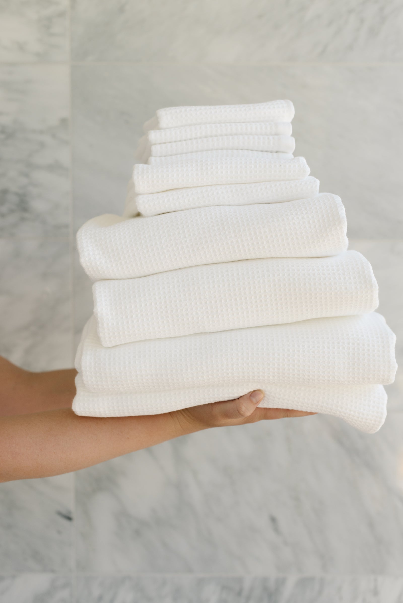Complete Waffle Bath Bundle in the color White. Photo of White Complete Waffle Bath Bundle taken while being held by a persons outreached hands