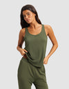 A woman in a Cozy Earth Women's Bamboo Stretch-Knit Lounge Tank stands against a light gray background, holding the hem of her olive green sleeveless top with one hand.|Color:Olive